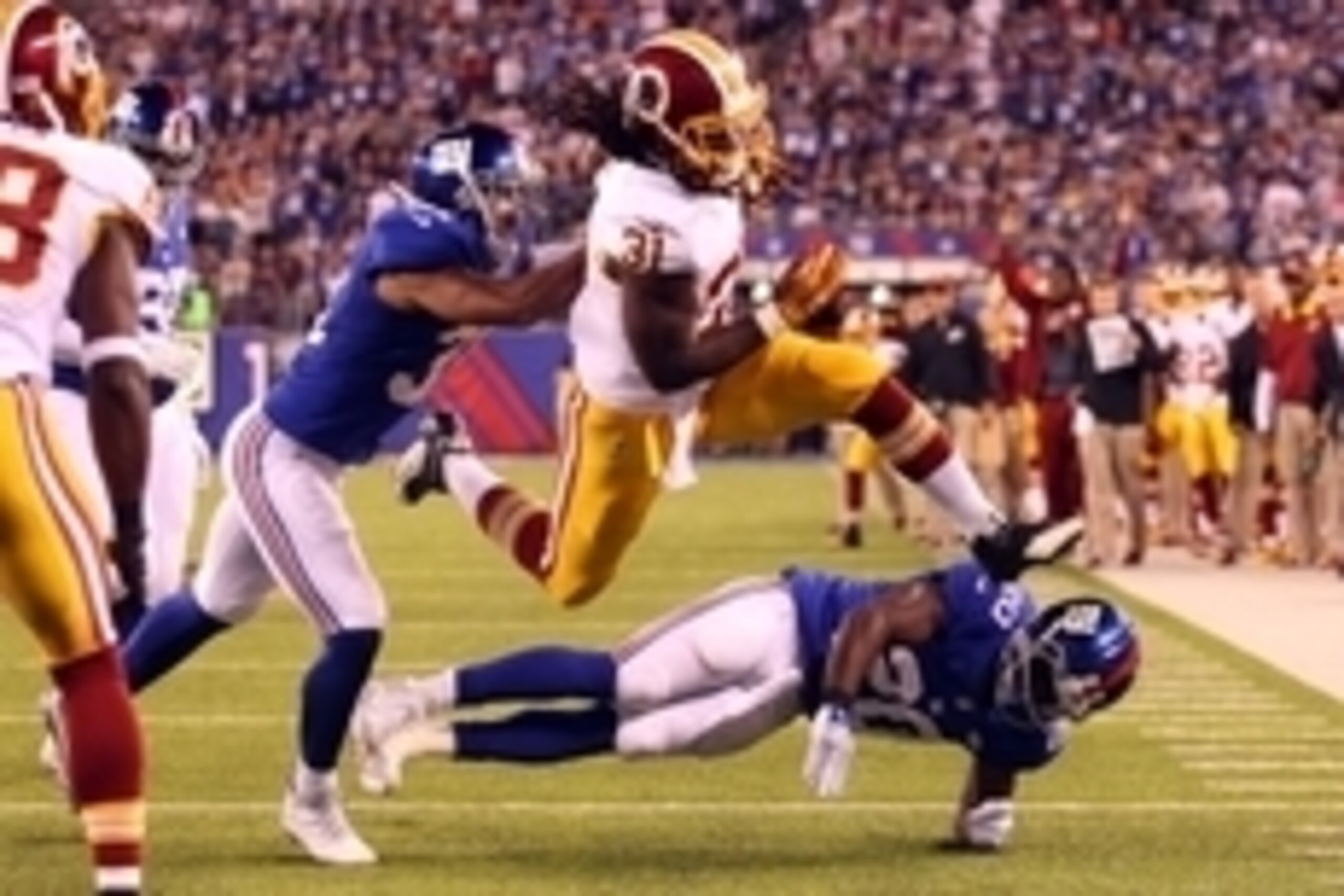 Sep 24, 2015; East Rutherford, NJ, USA; Washington Redskins running back Matt Jones (31) leaps over New York Giants corner back Prince Amukamara (20) but fumbles the ball out of the end zone for a touchback in front of New York Giants defensive back Trevi