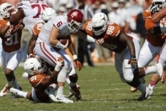 Oct 10, 2015; Dallas, TX, USA; Oklahoma Sooners quarterback Baker Mayfield (6) is sacked by Texas Longhorns defensive tackle Hassan Ridgeway (98) defensive end Bryce Cottrell (91) and Naashon Hughes (40) during Red River rivalry at Cotton Bowl Stadium. Ma