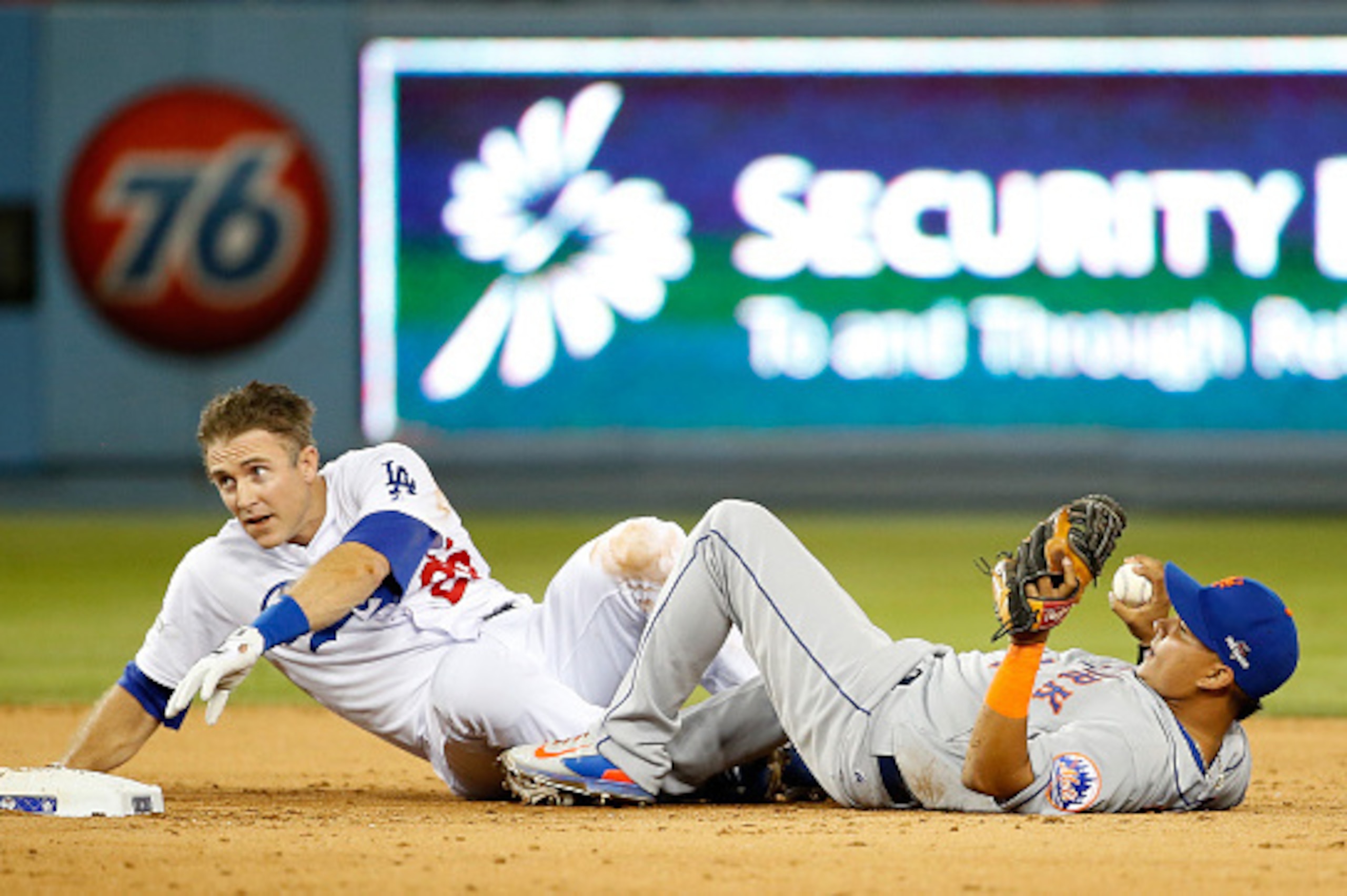 LOS ANGELES, CA - OCTOBER 10:  Ruben Tejada #11 of the New York Mets is hit by a slide by Chase Utley #26 of the Los Angeles Dodgers in the seventh inning in an attempt to turn a double play in game two of the National League Division Series at Dodger Sta