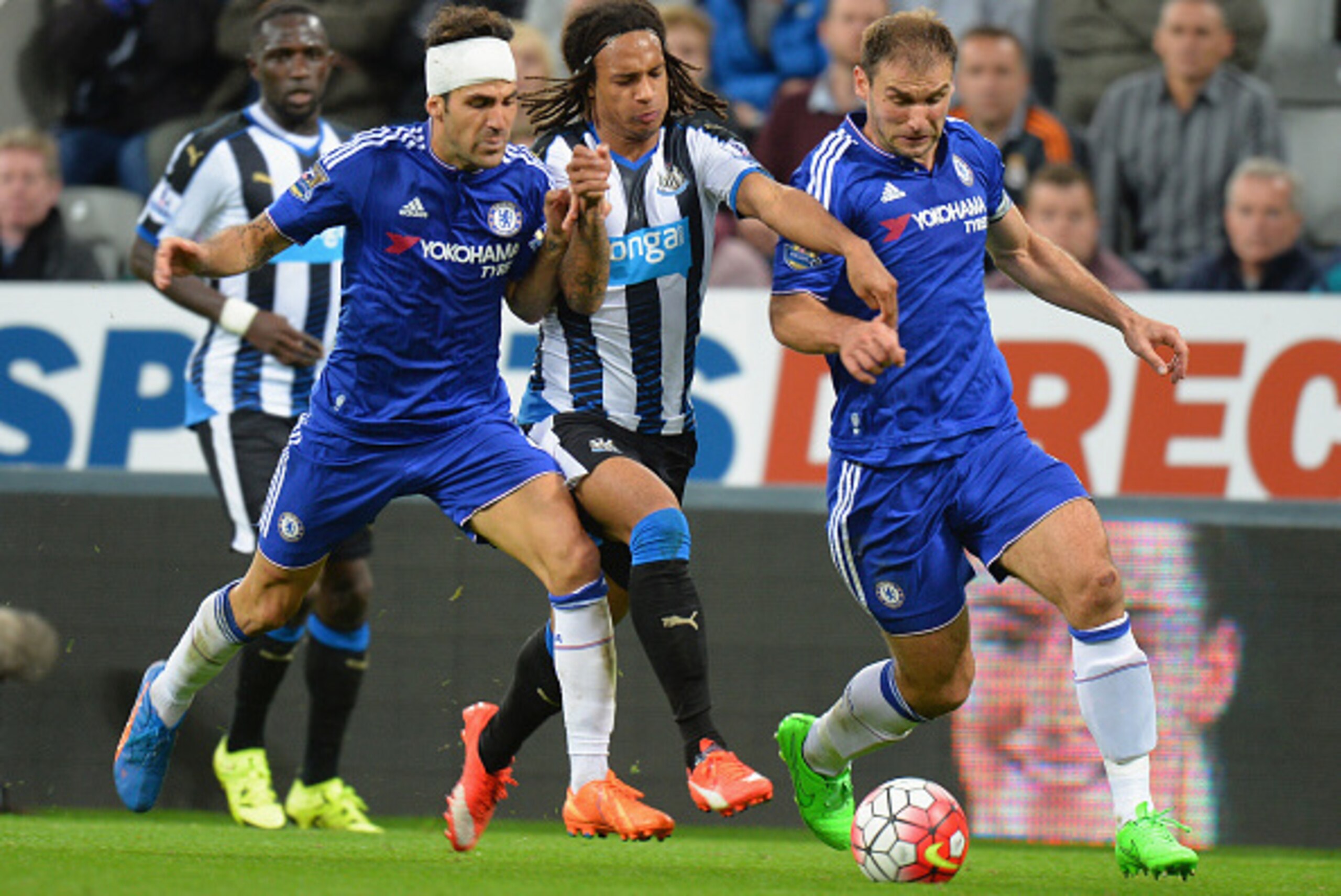 NEWCASTLE UPON TYNE, ENGLAND - SEPTEMBER 26:  Kevin Nbabu (C)of Newcastle United competes against Sesc Fabregas (L) and Branislav Ivanovic (R) of Chelsea  during the Barclays Premier League match between Newcastle United and Chelsea at St James' Park on S
