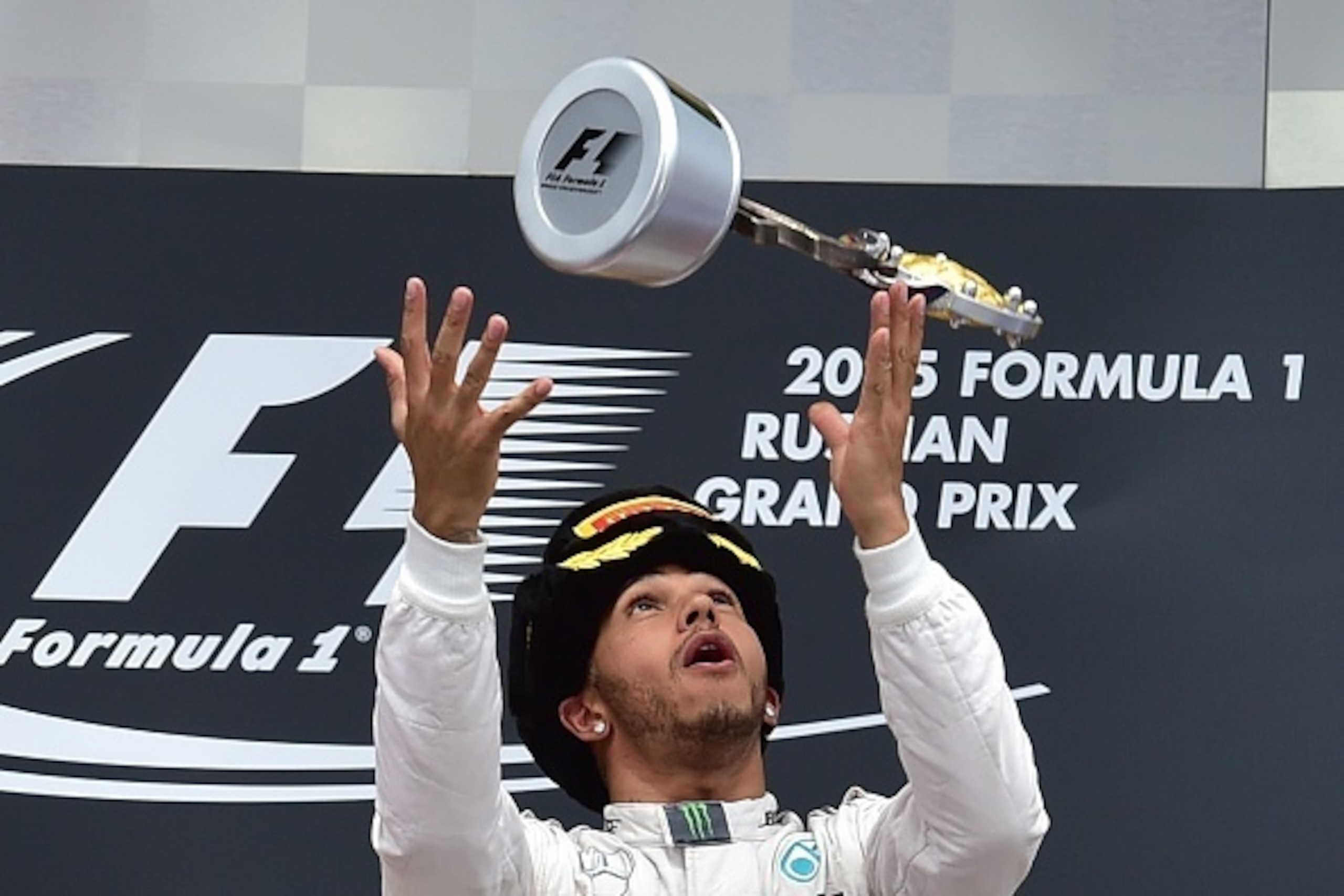 Mercedes AMG Petronas F1 Team's British driver Lewis Hamilton throws his trophy in the air as he celebrates winning the Russian Formula One Grand Prix at the Sochi Autodrom circuit on October 11, 2015. AFP PHOTO / ANDREJ ISAKOVIC (Photo credit shou Mercedes AMG Petronas F1 Team's British driver Lewis Hamilton throws his trophy in the air as he celebrates winning the Russian Formula One Grand Prix at the Sochi Autodrom circuit on October 11, 2015. AFP PHOTO / ANDREJ ISAKOVIC (Photo credit shou
