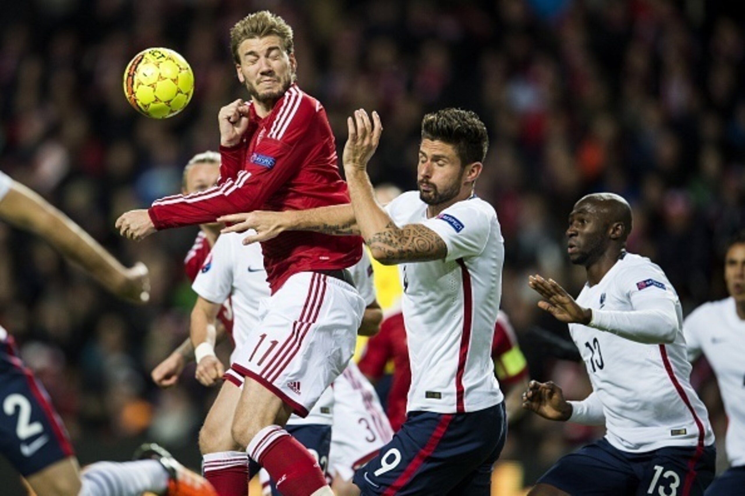 Denmark's forward Nicklas Bendtner (L) and France's forward Olivier Giroud (C ) vie for the ball during the friendly international football match between Denmark and the hosts of the Euro 2016 France in Copenhagen on October 11, 2015. AFP PHOTO / ODD ANDE