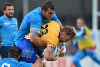 Romania's centre Csaba Gal (R) is tackled  during a Pool D match of the 2015 Rugby World Cup between Italy and Romania at Sandy Park in Exeter, soutwest England, on October 11, 2015.  AFP PHOTO / GLYN KIRK

RESTRICTED TO EDITORIAL USE, NO USE IN LIVE MATC