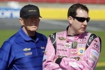 Oct 11, 2015; Concord, NC, USA; Sprint Cup Series driver Kyle Busch (18) and team owner Joe Gibbs talk before the Bank of America 500 at Charlotte Motor Speedway. Mandatory Credit: Peter Casey-USA TODAY Sports