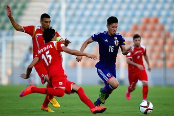 MUSCAT, OMAN - OCTOBER 08:  Hotaru Yamaguchi of Japan compete for the ball with Alaa Al Shbbli and Abdulrazak Al Husein of Syria during the 2018 FIFA World Cup Asian Group E qualifying match between Syria and Japan at Seeb Stadium on October 8, 2015 in Mu