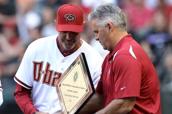 PHOENIX, AZ - APRIL 06:  Manager Kirk Gibson of the Arizona Diamondbacks receives the NL Manager of the Year Award from GM Kevin Towers before the Opening Day game against the San Francisco Giants at Chase Field on April 6, 2012 in Phoenix, Arizona.  The 