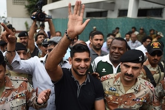 British boxer Amir Khan waves to fans in Karachi on August 26, 2015. Khan visited Karachi's troubled Lyari area, which is frequently hit by gang violence but also known for producing talented footballers and boxers. AFP PHOTO / RIZWAN TABASSUM        (Pho