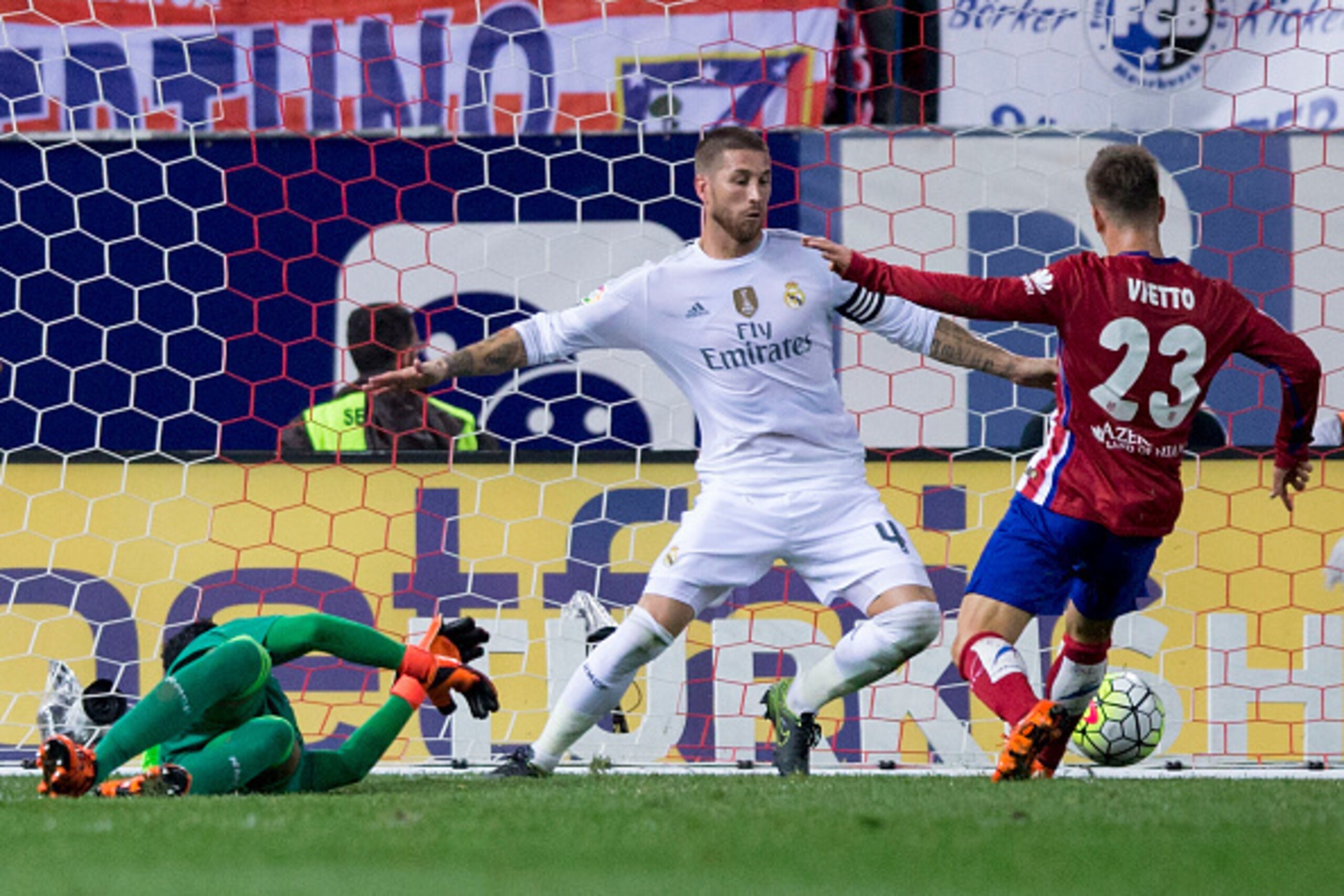 MADRID, SPAIN - OCTOBER 04: Luciano Dario Vietto (R) of Atletico de Madrid scores their opening goal against Sergio Ramos (2ndR) of Real Madrid CF and his teammate goalkeeper Keylor Navas (R) during the La Liga match between Club Atletico de Madrid and Re