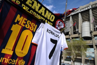 MADRID, SPAIN - MARCH 23:  Shirts bearing the names of Lionel Messi of FC Barcelona and Cristiano Ronaldo of Real Madrid CF are see at a merchandise stall prior to the La Liga match between Real Madrid CF and FC Barcelona at estadio Santiago Bernabeu on M