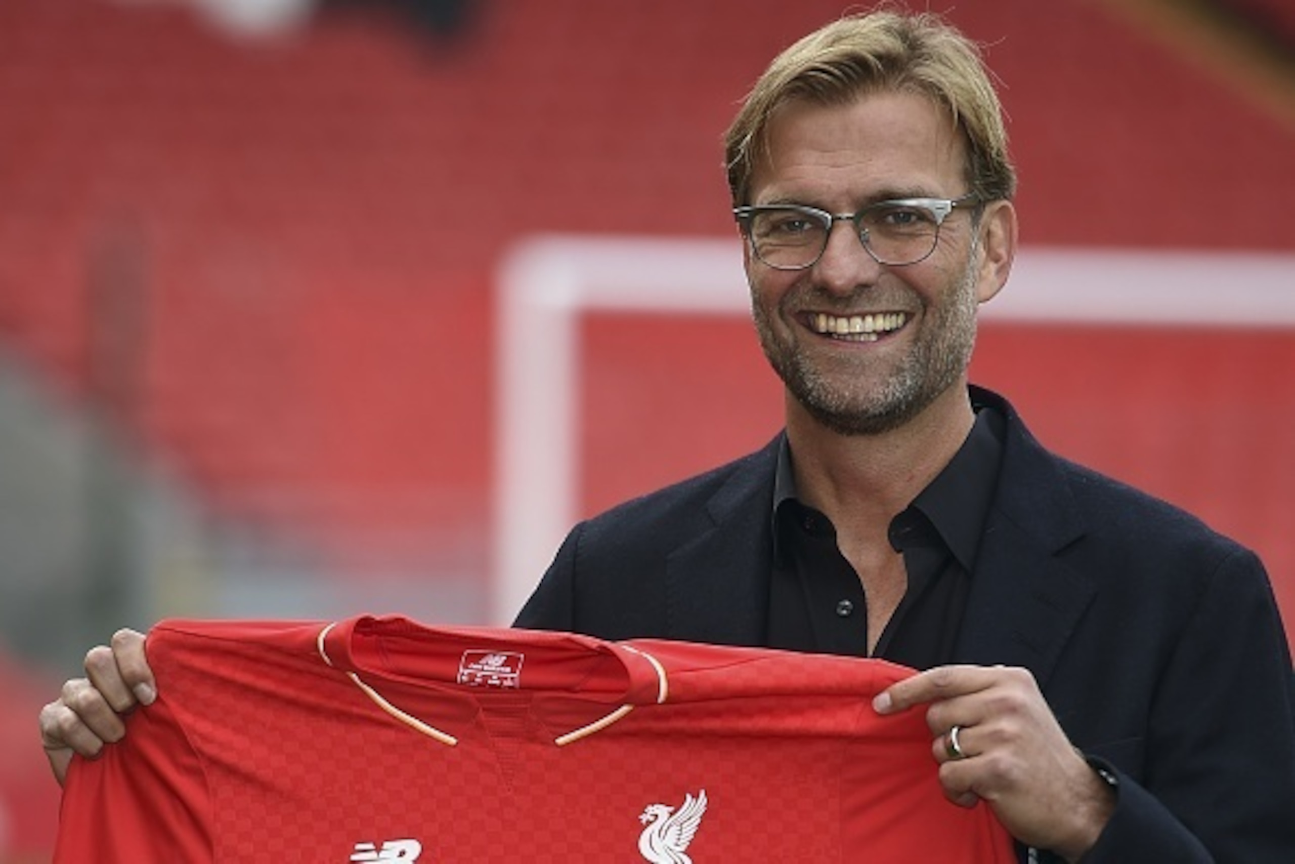 Liverpool's new German manager Jurgen Klopp poses with a team jersey after a press conference to announce his new appointment at Anfield in Liverpool, northwest England, on October 9, 2015. Klopp described his job as 'the biggest challenge' in world footb
