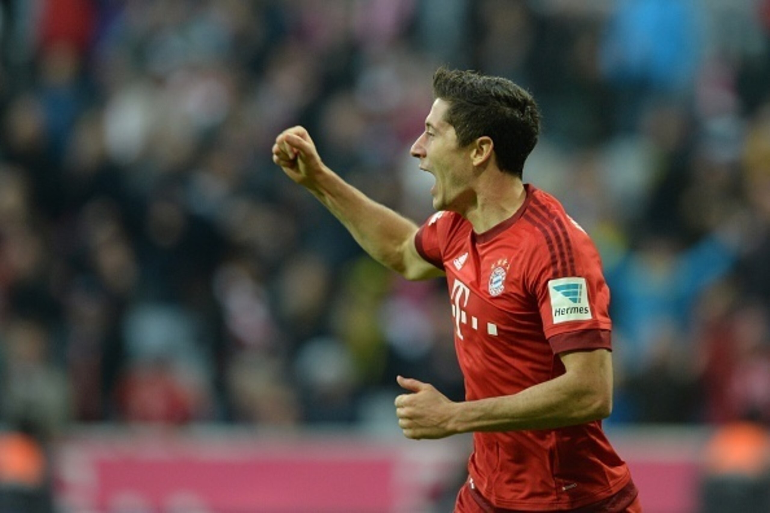 Bayern Munich's Polish striker Robert Lewandowski celebrates after he scores the second goal for Munich during the German first division Bundesliga football match FC Bayern Munich vs Borussia Dortmund in Munich, southern Germany, on October 4, 2015.  AFP 