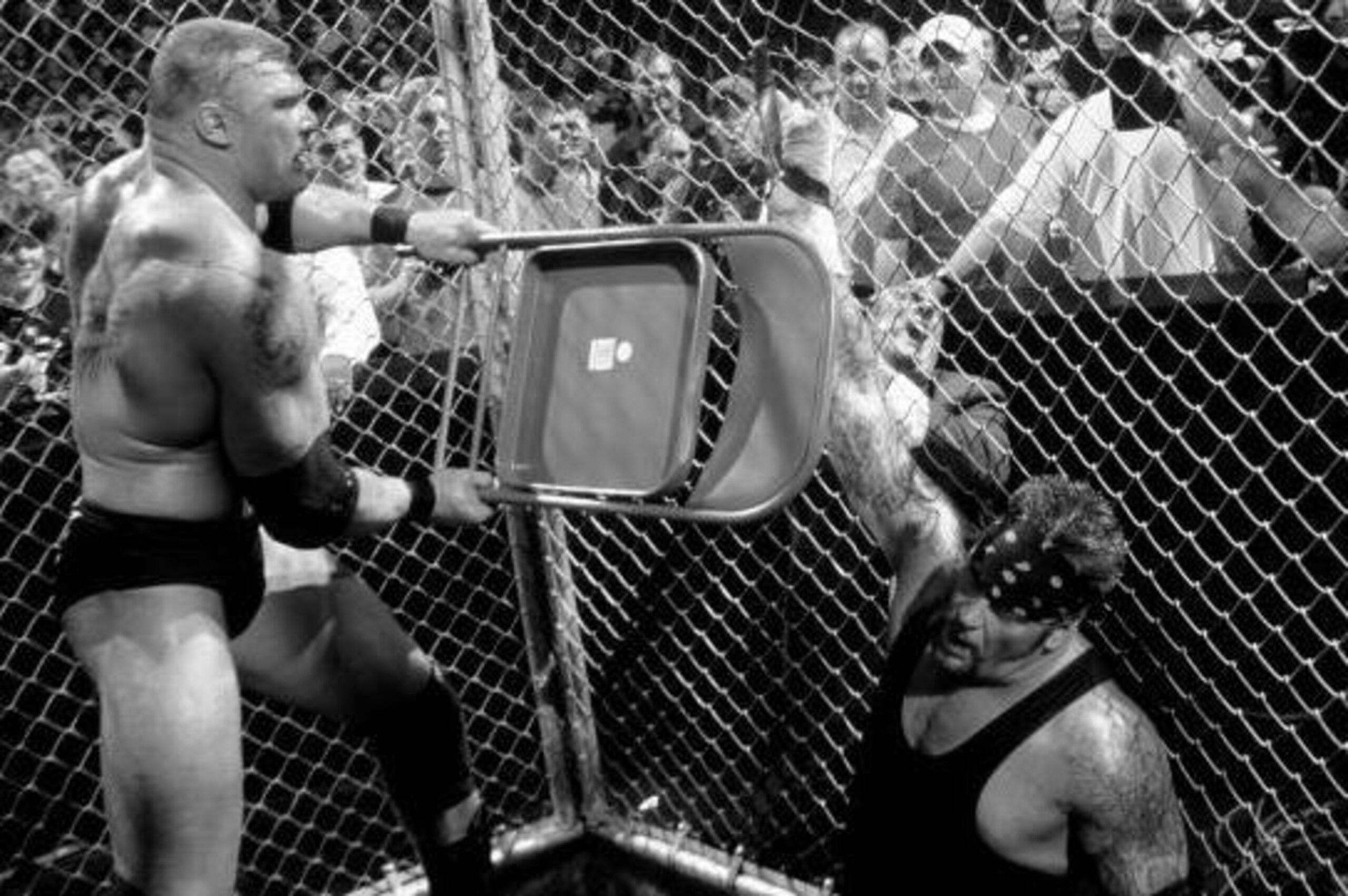 Brock Lesnar takes a chair to Undertaker's broken hand.