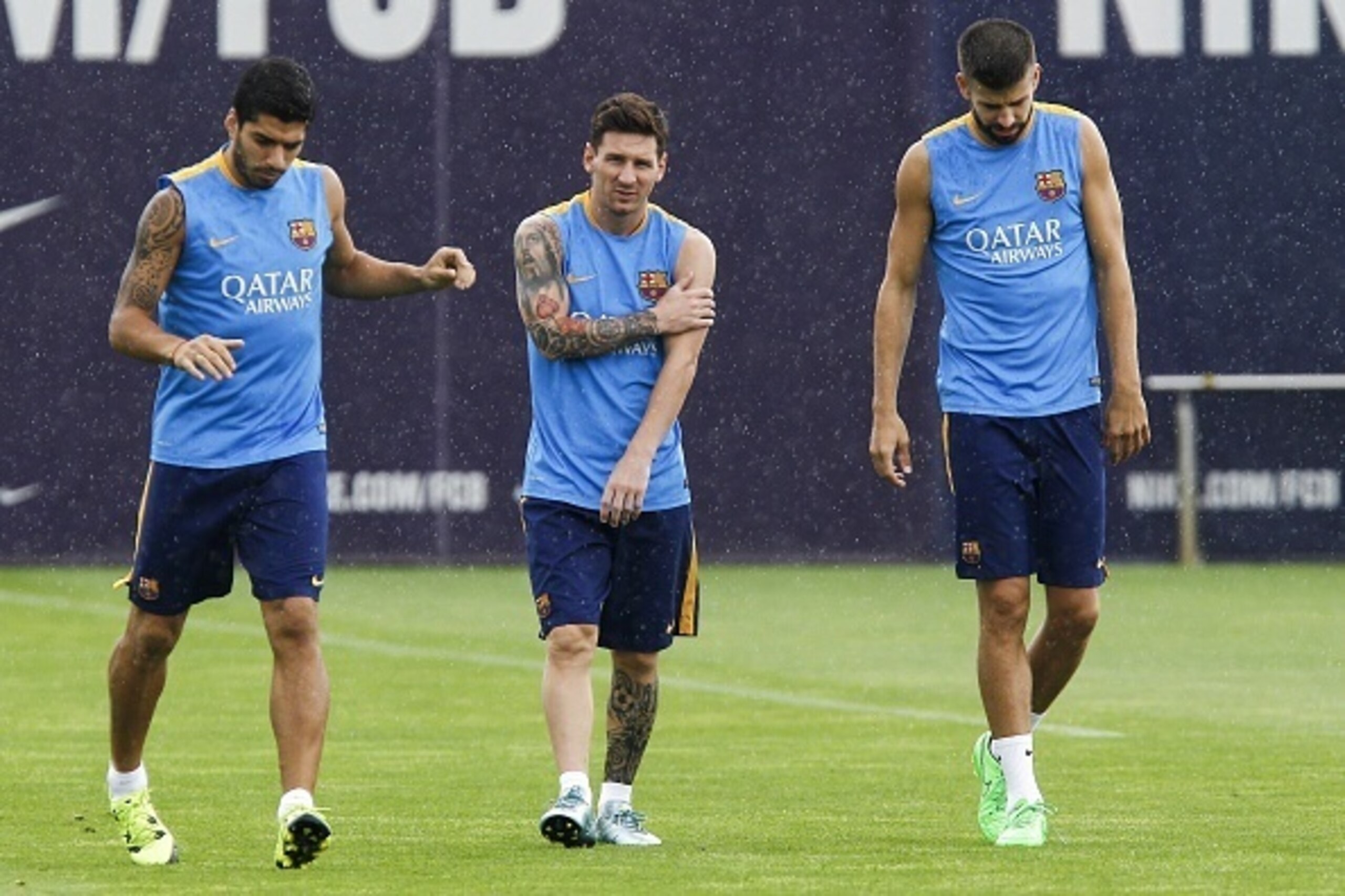 Barcelona's Argentinian forward Lionel Messi (C) Barcelona's Uruguayan forward Luis Suarez (L) and Barcelona's defender Gerard Pique (R) take part in a training session at the Sports Center FC Barcelona Joan Gamper in Sant Joan Despi, near Barcelona on Au