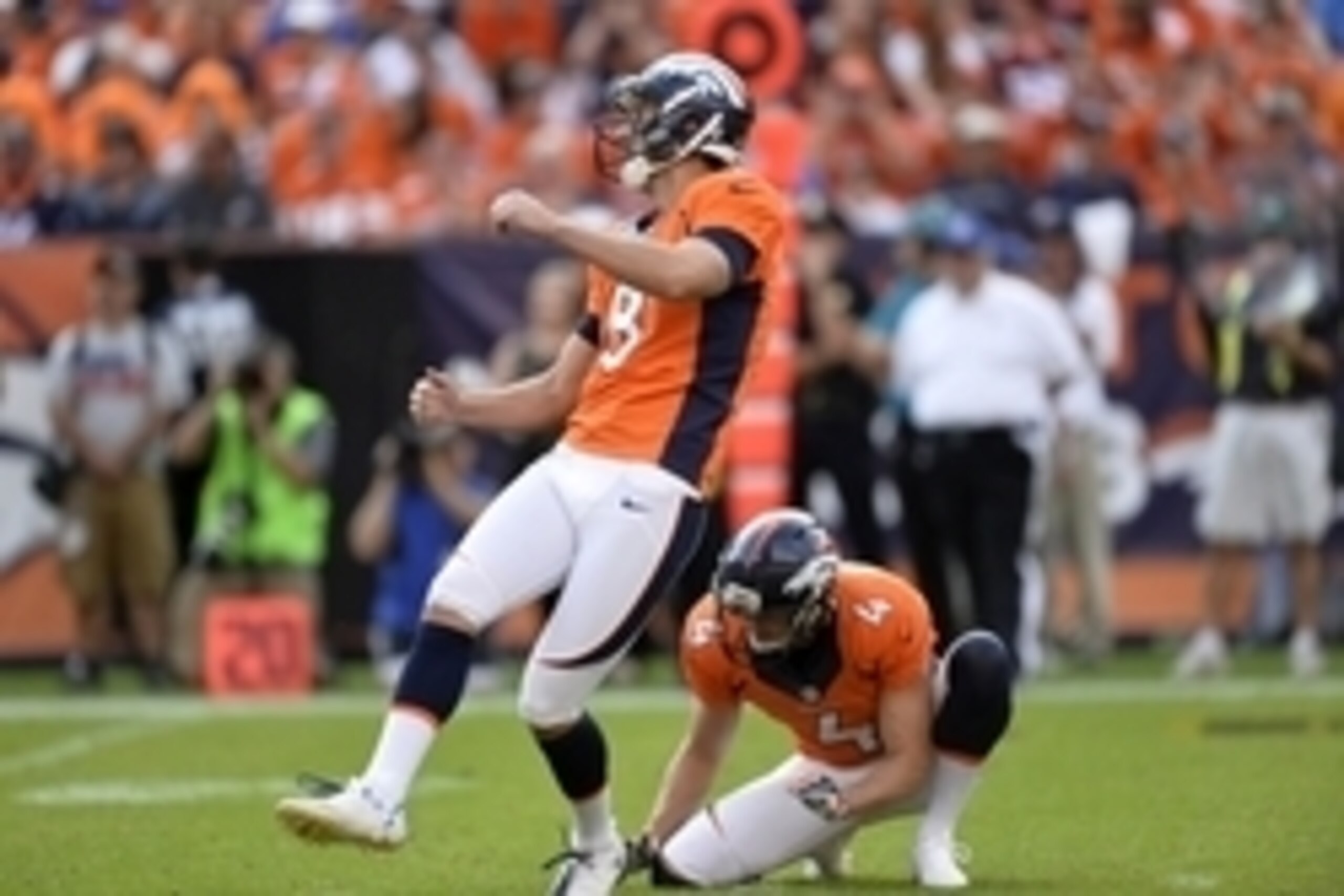 Sep 13, 2015; Denver, CO, USA; Denver Broncos kicker Brandon McManus (8) kicks a field goal as punter Britton Colquitt (4) holds in the fourth quarter against the Baltimore Ravens at Sports Authority Field at Mile High. The Broncos won 19-13. Mandatory Cr