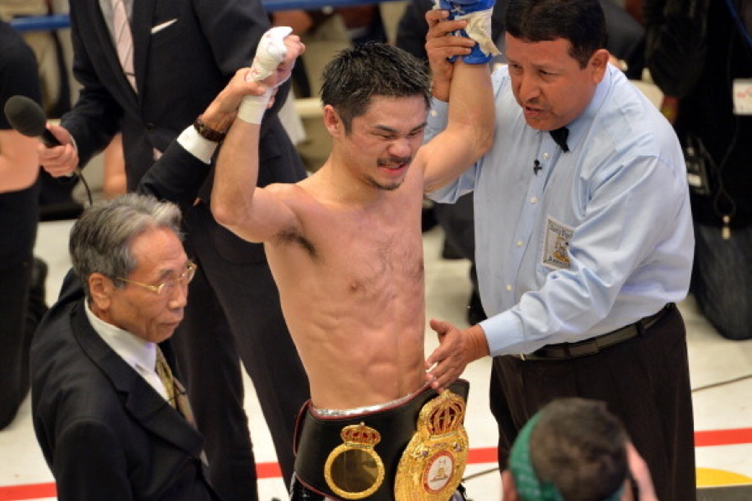 Japan's Kohei Kono (C) celebrates after beating Denkaosan Kaovichit of Thailand (not pcitured) in the eighth round of the WBA super flyweight title match in Tokyo on March 26, 2014. Kono defeated Denkaosan with a knockout and clinched the belt. AFP PHOTO 