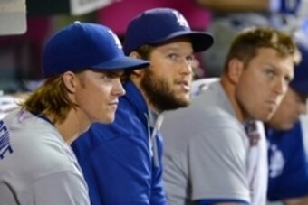 Sep 7, 2015; Anaheim, CA, USA; Los Angeles Dodgers starting pitcher Zack Greinke (21) and starting pitcher Clayton Kershaw (22) and catcher A.J. Ellis (17) in the dugout during the seventh of the game against the Los Angeles Angels at Angel Stadium of Ana