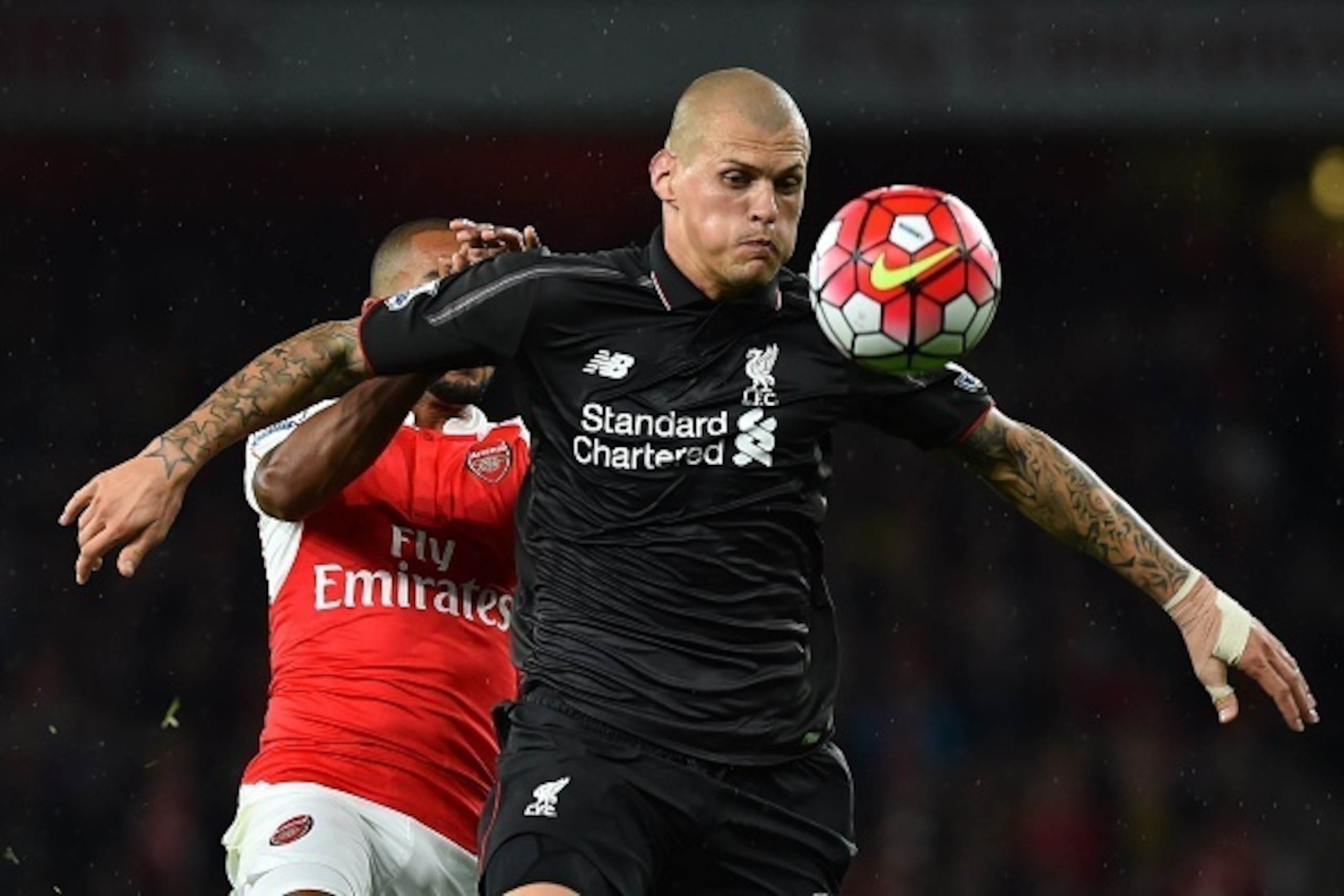 Liverpool's Slovakian defender Martin Skrtel holds off Arsenal's English midfielder Theo Walcott during the English Premier League football match between Arsenal and Liverpool at the Emirates stadium, north London on August 24, 2015. AFP PHOTO / BEN STANS