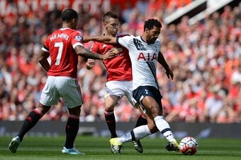 Tottenham Hotspur's Belgian midfielder Mousa Dembele (R) vies with Manchester United's French midfielder Morgan Schneiderlin and Manchester United's Dutch midfielder Memphis Depay (L) during the English Premier League football match between Manchester Uni
