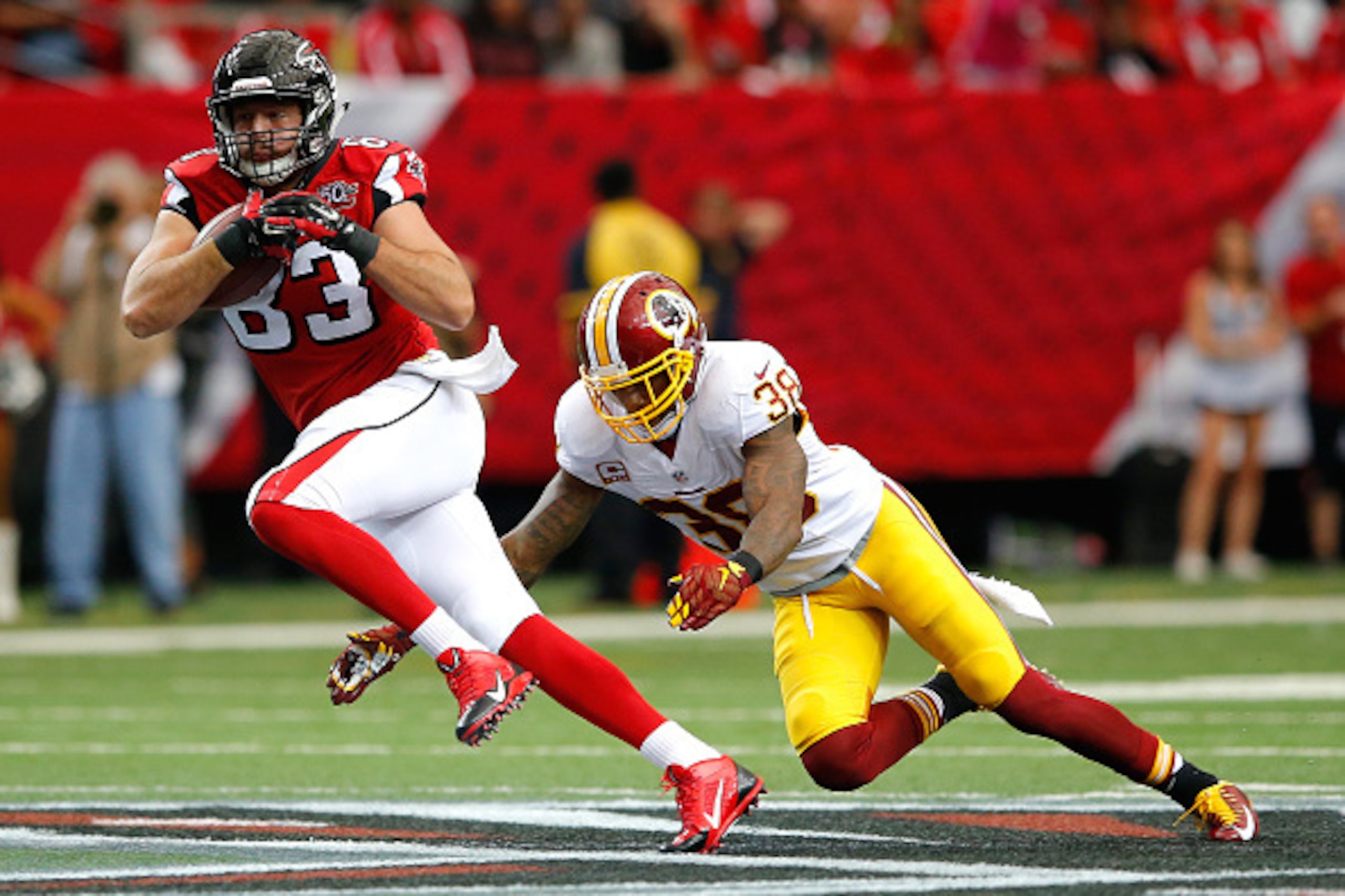 ATLANTA, GA - OCTOBER 11:  Jacob Tamme #83 of the Atlanta Falcons rushes away from Dashon Goldson #38 of the Washington Redskins at Georgia Dome on October 11, 2015 in Atlanta, Georgia.  (Photo by Kevin C. Cox/Getty Images)