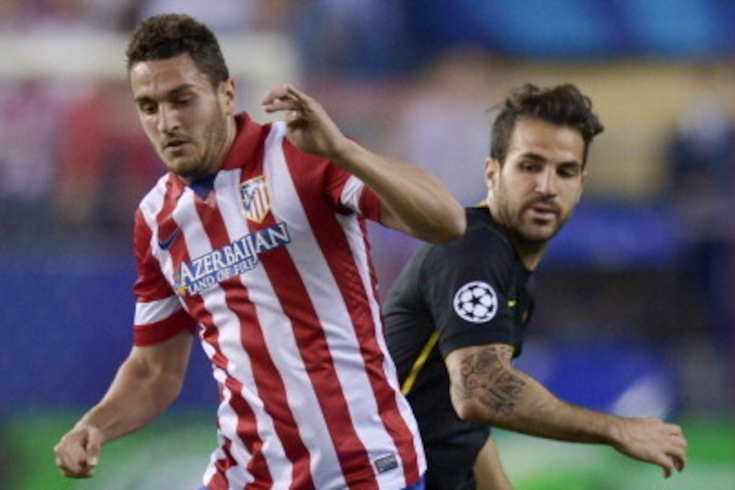 Atletico Madrid's midfielder Koke (L) vies with Barcelona's midfielder Cesc Fabregas during the UEFA Champions League quarter final football match Club Atletico de Madrid vs Barcelona at the Vicente Calderon stadium in Madrid on April 9, 2014. AFP PHOTO /