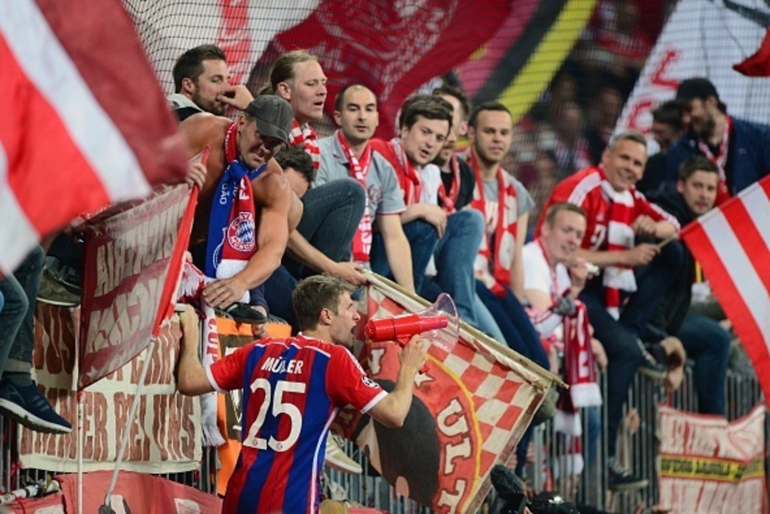 Bayern Munich's midfielder Thomas Mueller leads the fans' celebrations after the UEFA Champions League second-leg quarter-final football match Bayern Munich v FC Porto in Munich, southern Germany on April 21, 2015. Bayern Munich won the match 6-1. AFP PHO