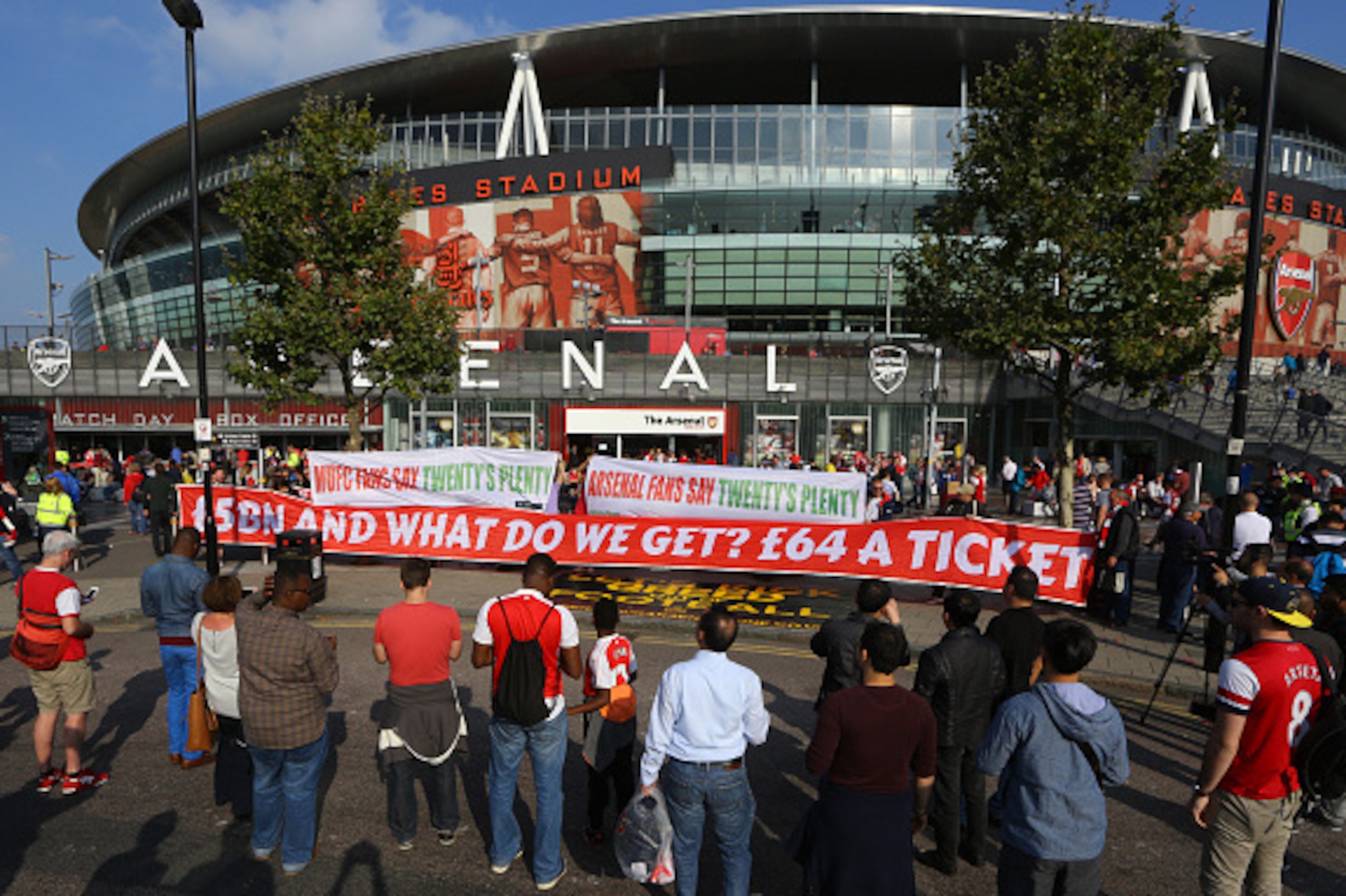 LONDON, ENGLAND - OCTOBER 04:  Arsenal and Manchester United fans protest about high ticket prices with banners outside the stadium before the Barclays Premier League match between Arsenal and Manchester United at the Emirates Stadium on October 04, 2015 