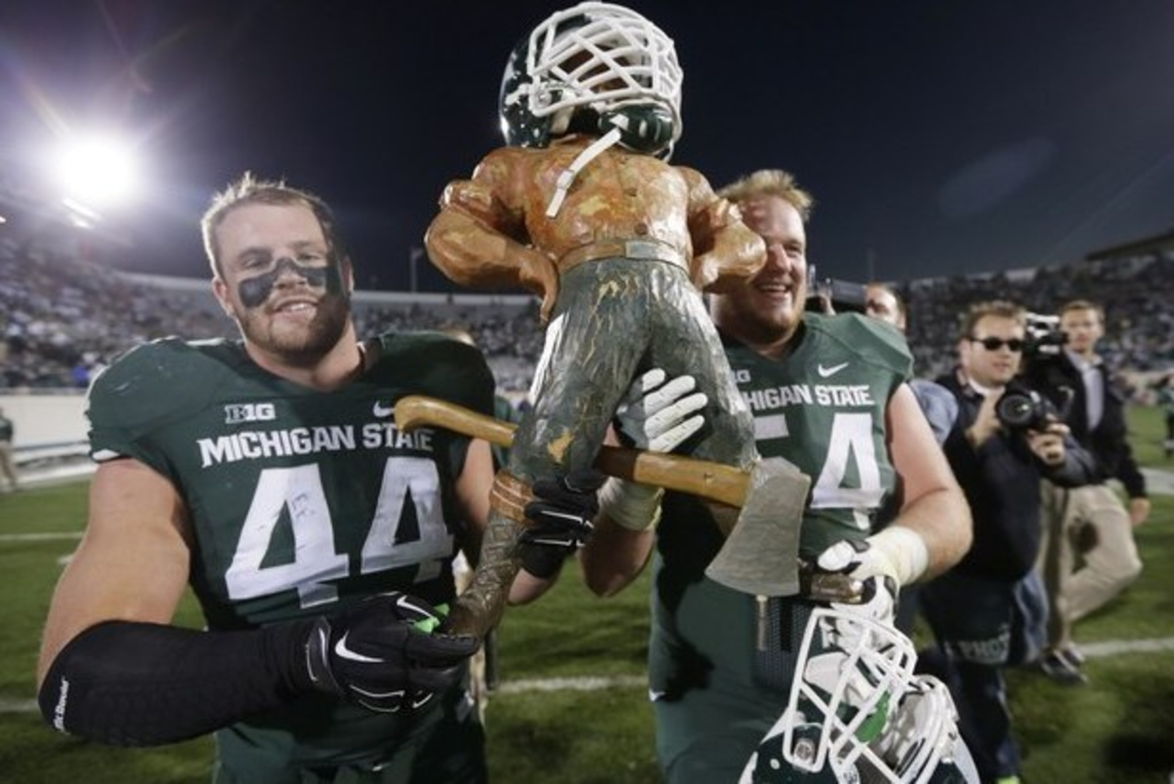 Marcus Rush placed his helmet on the Paul Bunyan Trophy after MSU topped Michigan in 2014.