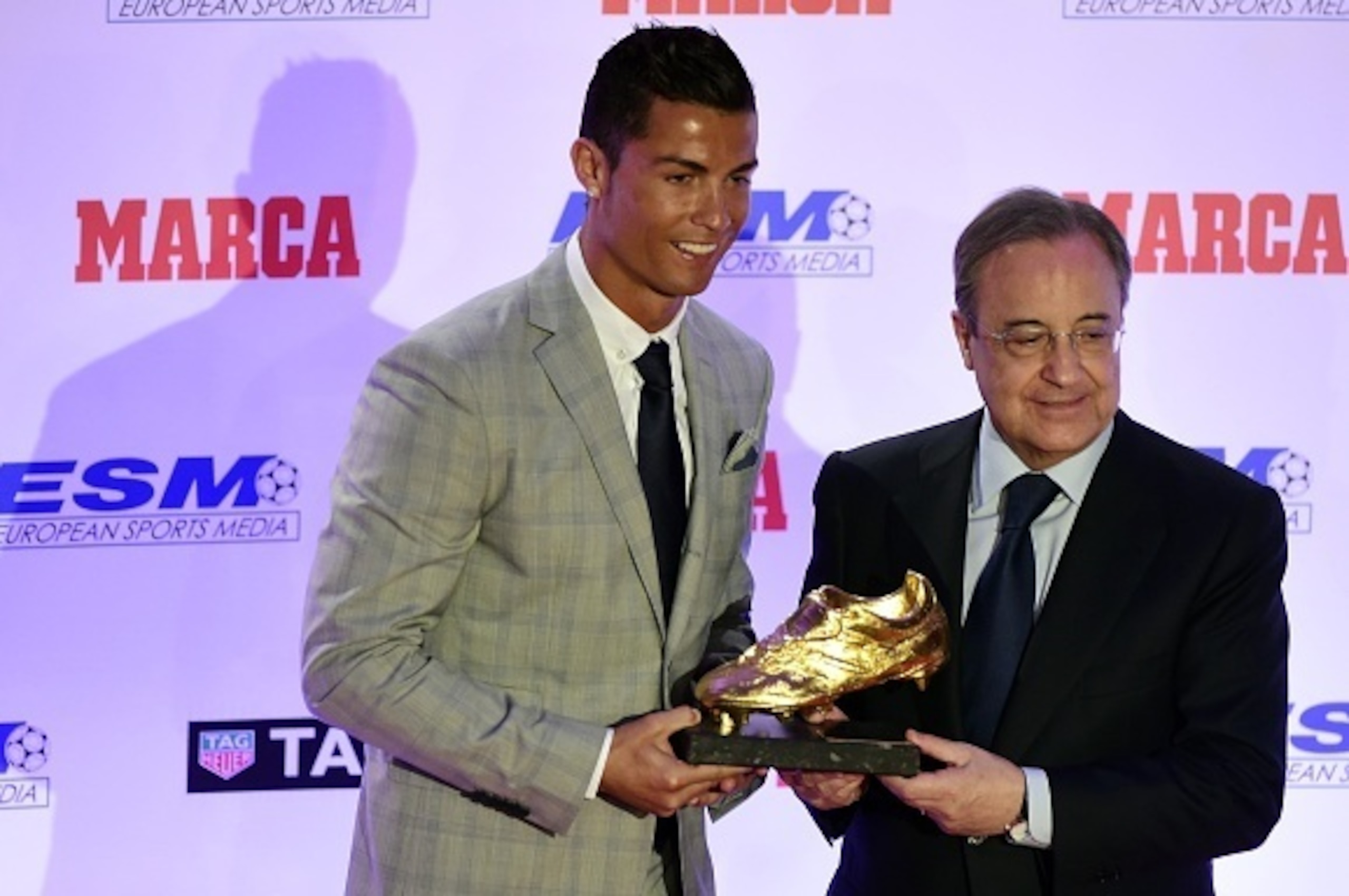 Real Madrid's Portuguese forward Cristiano Ronaldo (L) receives his fourth European Golden Shoe from Real Madrid's president Florentino Perez, on October 13, 2015 in Madrid. Cristiano, who ended the season with 48 goals from 35 appearances, won the Golden