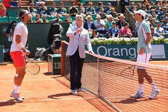 PARIS, FRANCE - JUNE 07:  Umpire Pascal Maria tosses the coin as Rafael Nadal of Spain and Novak Djokovic of Serbia watch before their men's singles semi-final match on day thirteen of the French Open at Roland Garros on June 7, 2013 in Paris, France.  (P