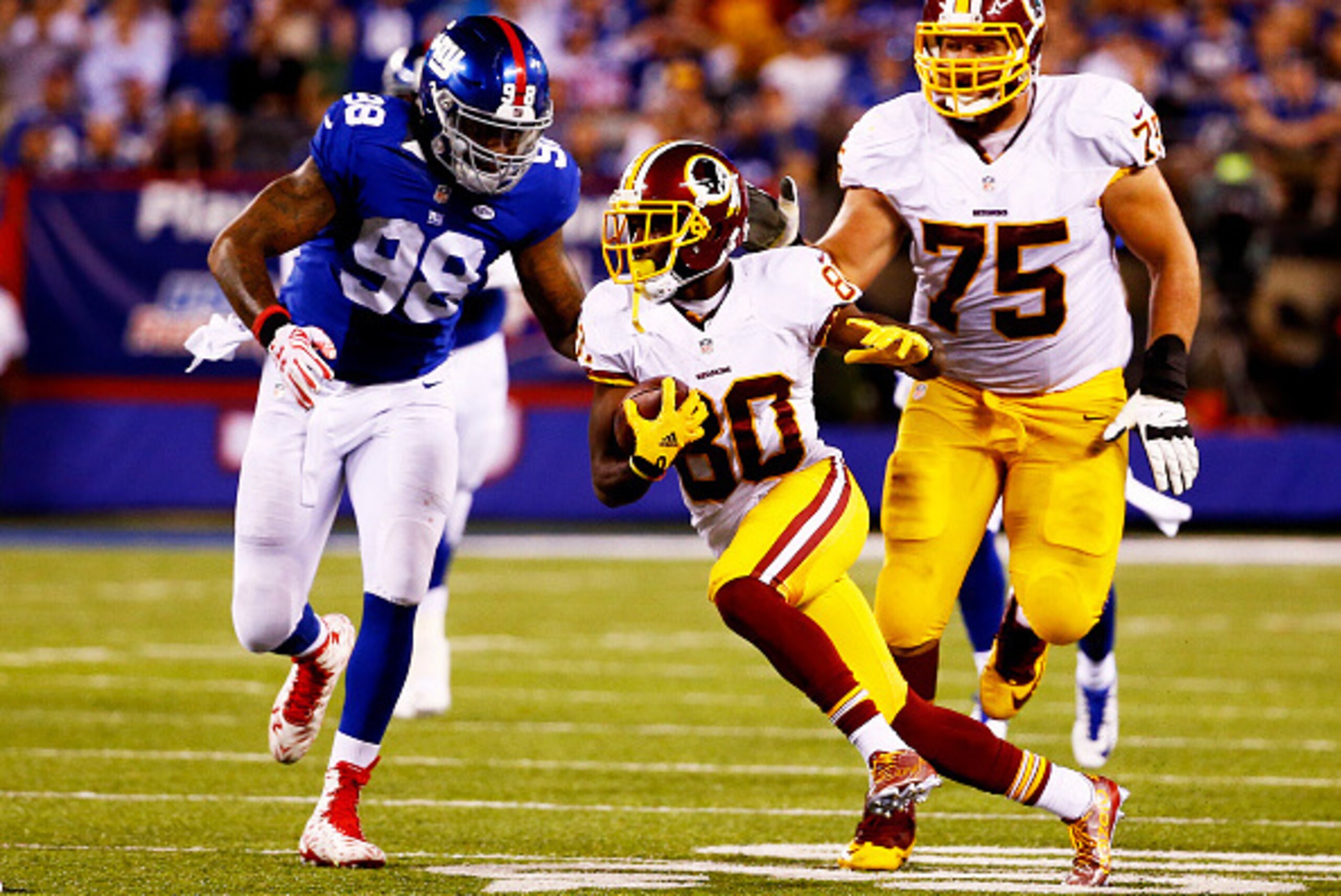 EAST RUTHERFORD, NJ - SEPTEMBER 24:   Jamison Crowder #80 of the Washington Redskins carries the ball as  Damontre Moore #98 of the New York Giants defends in the first half at MetLife Stadium on September 24, 2015 in East Rutherford, New Jersey.  (Photo 