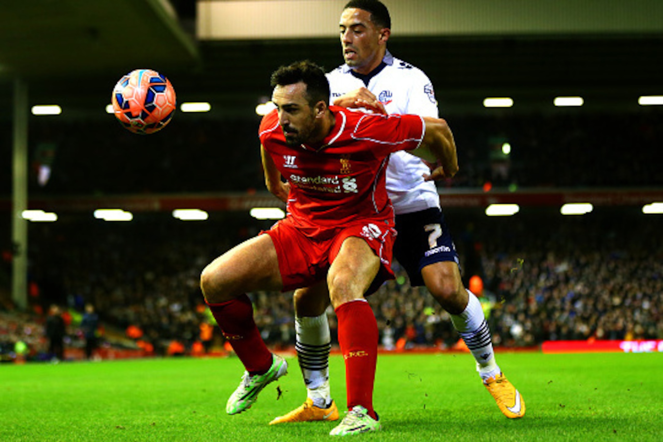 LIVERPOOL, ENGLAND - JANUARY 24:  Jose Enrique of Liverpool shields the ball from Liam Feeney of Bolton Wanderers during the FA Cup Fourth Round match between Liverpool and Bolton Wanderers at Anfield on January 24, 2015 in Liverpool, England.  (Photo by 