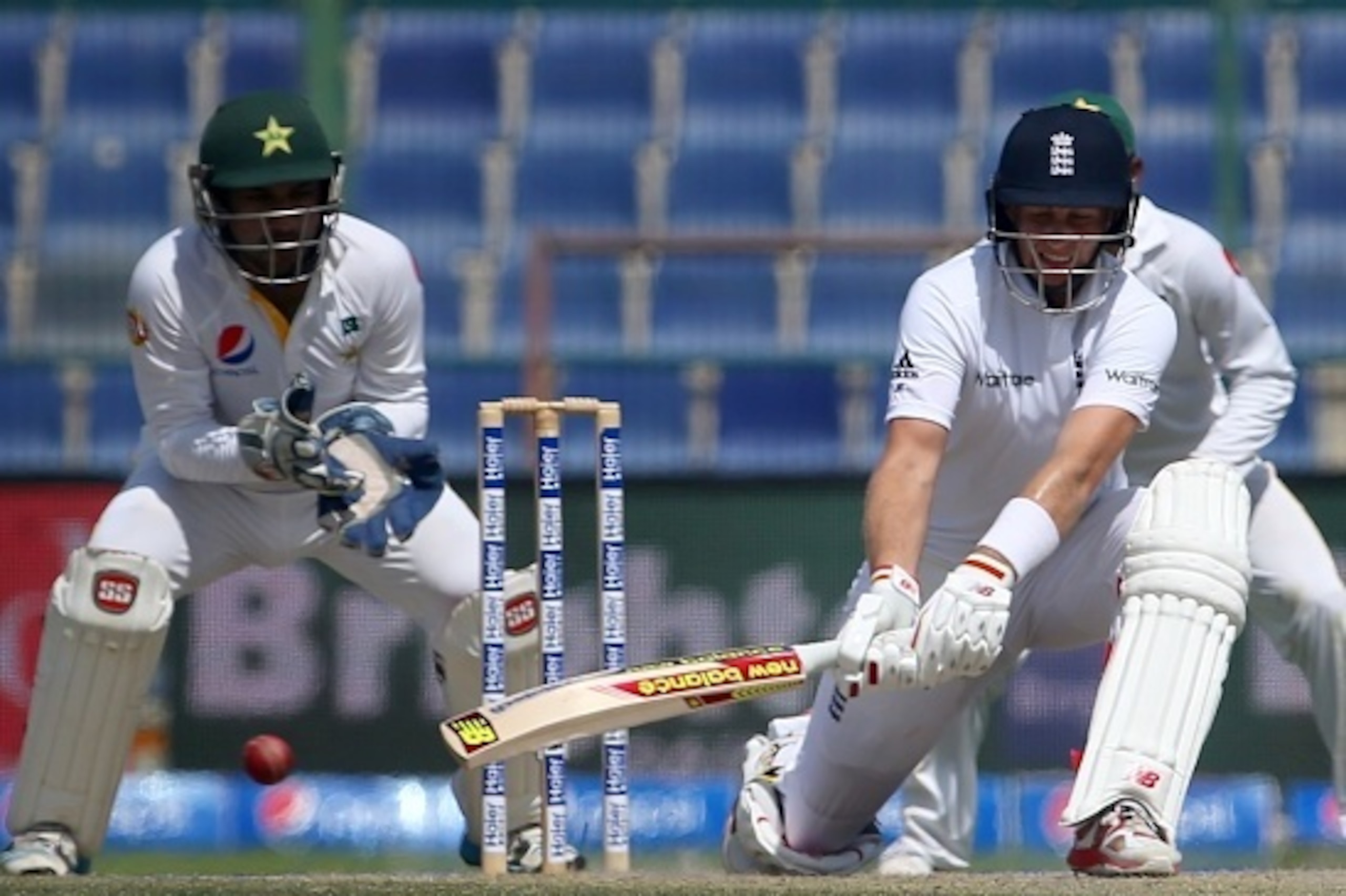 England's Joe Root (R) plays a shot past Pakistan's wicketkeeper Sarfraz Ahmed during the fourth day's play of the first cricket Test match between Pakistan and England at The Sheikh Zayed International Cricket Stadium in Abu Dhabi on October 16, 2015. AF