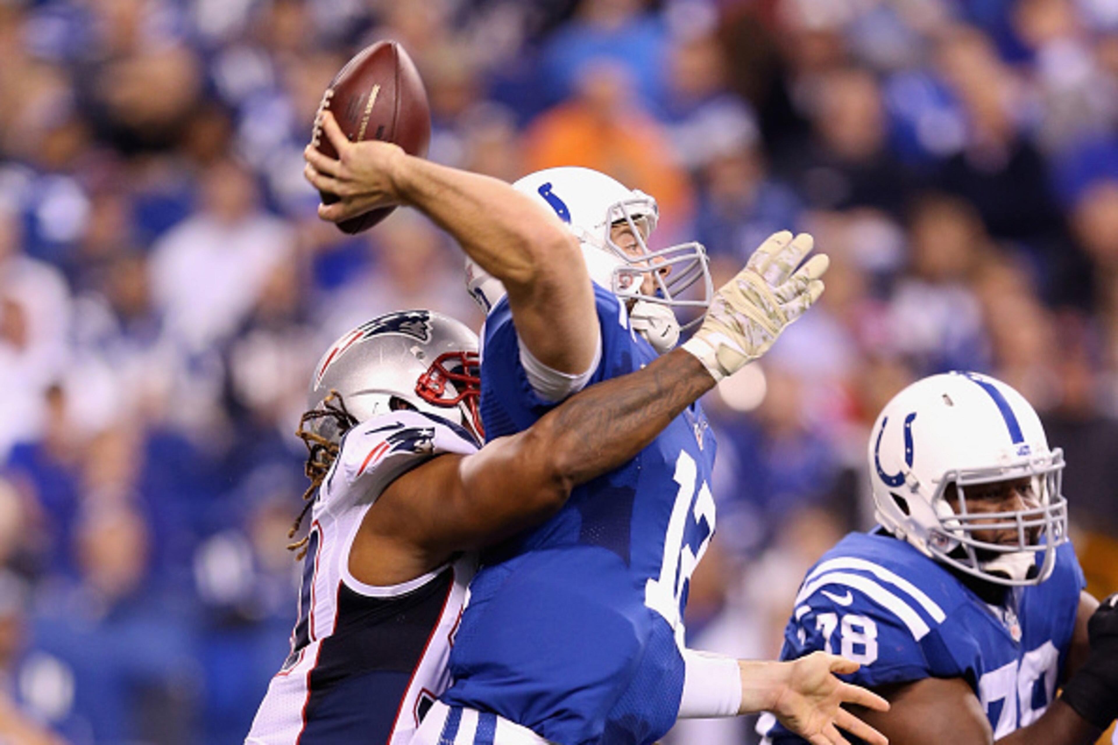 INDIANAPOLIS, IN - NOVEMBER 16: Andrew Luck #12  of the Indianapolis Colts is hit as he throws the ball during the 42-20 loss to the New England Patriots at Lucas Oil Stadium on November 16, 2014 in Indianapolis, Indiana.  (Photo by Andy Lyons/Getty Image