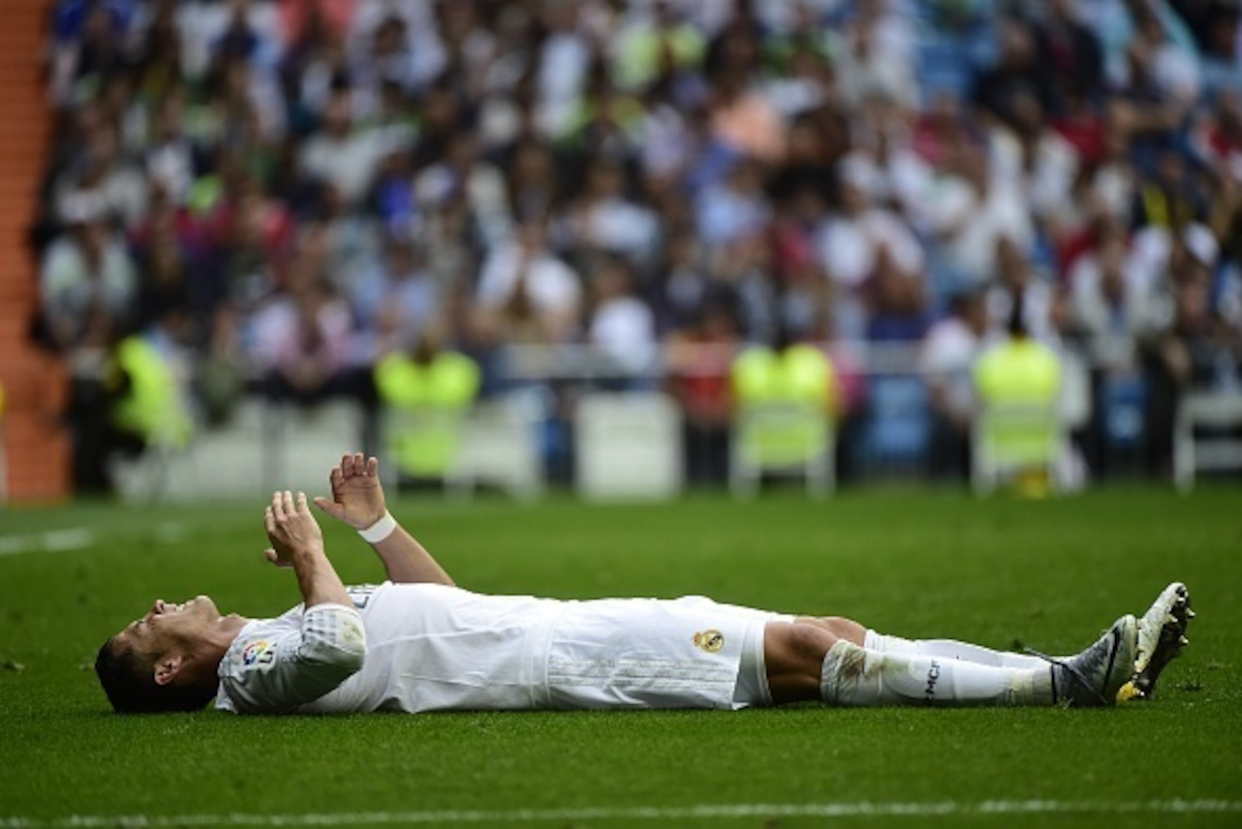 Real Madrid's Portuguese forward Cristiano Ronaldo lies on the field after being injuried during the Spanish league football match Real Madrid CF vs Levante UD at the Santiago Bernabeu stadium in Madrid on October 17, 2015. AFP PHOTO/ PIERRE-PHILIPPE MARC