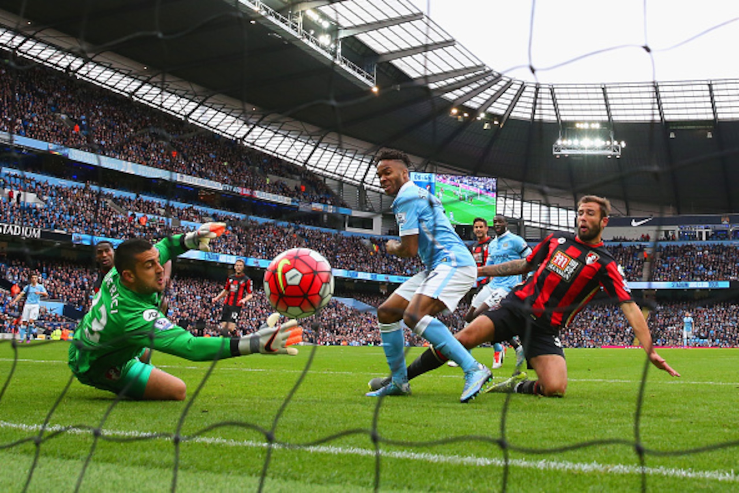 MANCHESTER, ENGLAND - OCTOBER 17:  Raheem Sterling of Manchester City scores his team's first goal past Adam Federici of Bournemouth during the Barclays Premier League match between Manchester City and A.F.C. Bournemouth at Etihad Stadium on October 17, 2