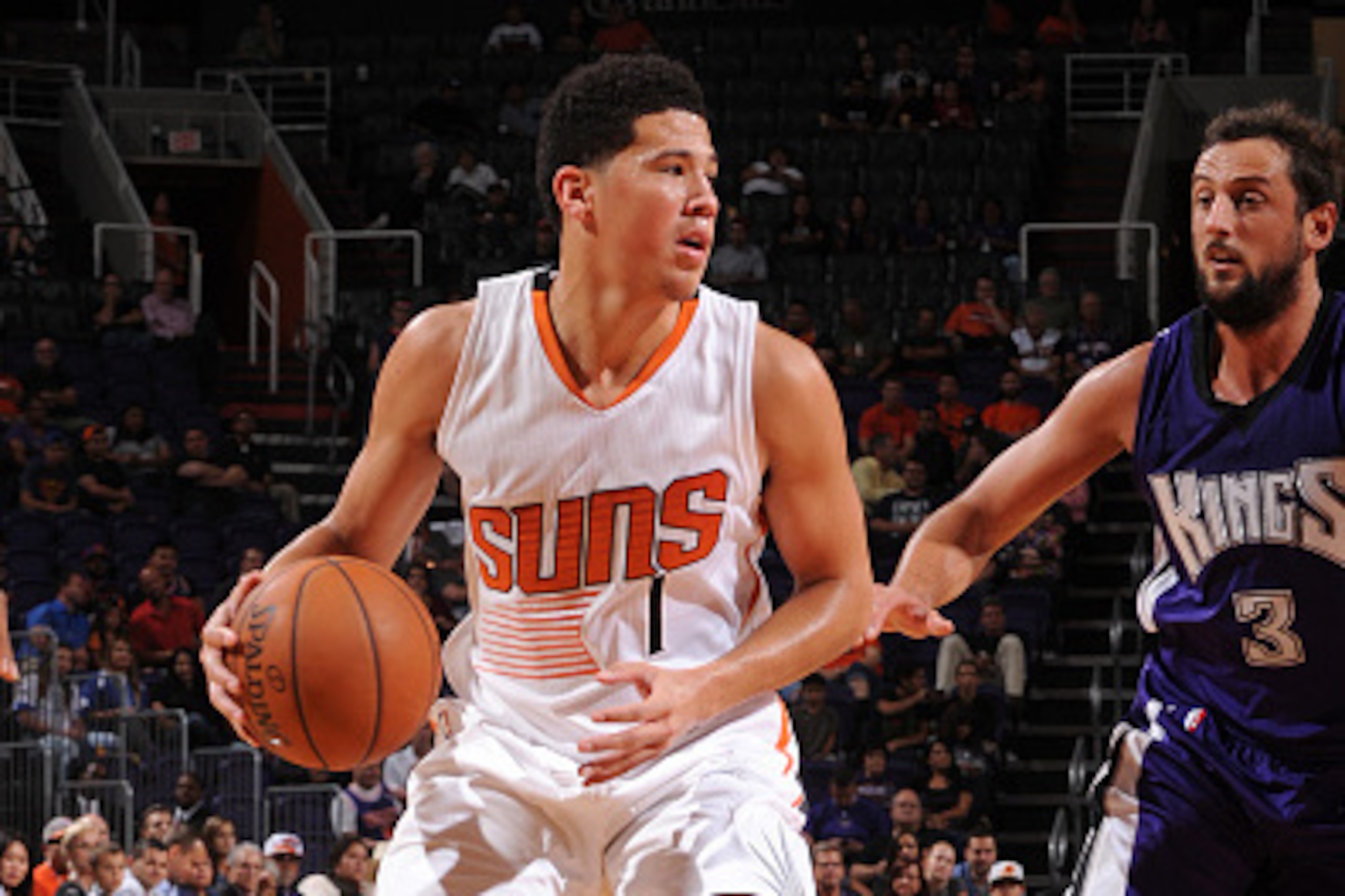 PHOENIX, AZ - OCTOBER 7:  Devin Booker #1 of the Phoenix Suns handles the ball against Marco Belinelli #3 of the Sacramento Kings on October 7, 2015 at Talking Stick Resort Arena in Phoenix, Arizona. NOTE TO USER: User expressly acknowledges and agrees th