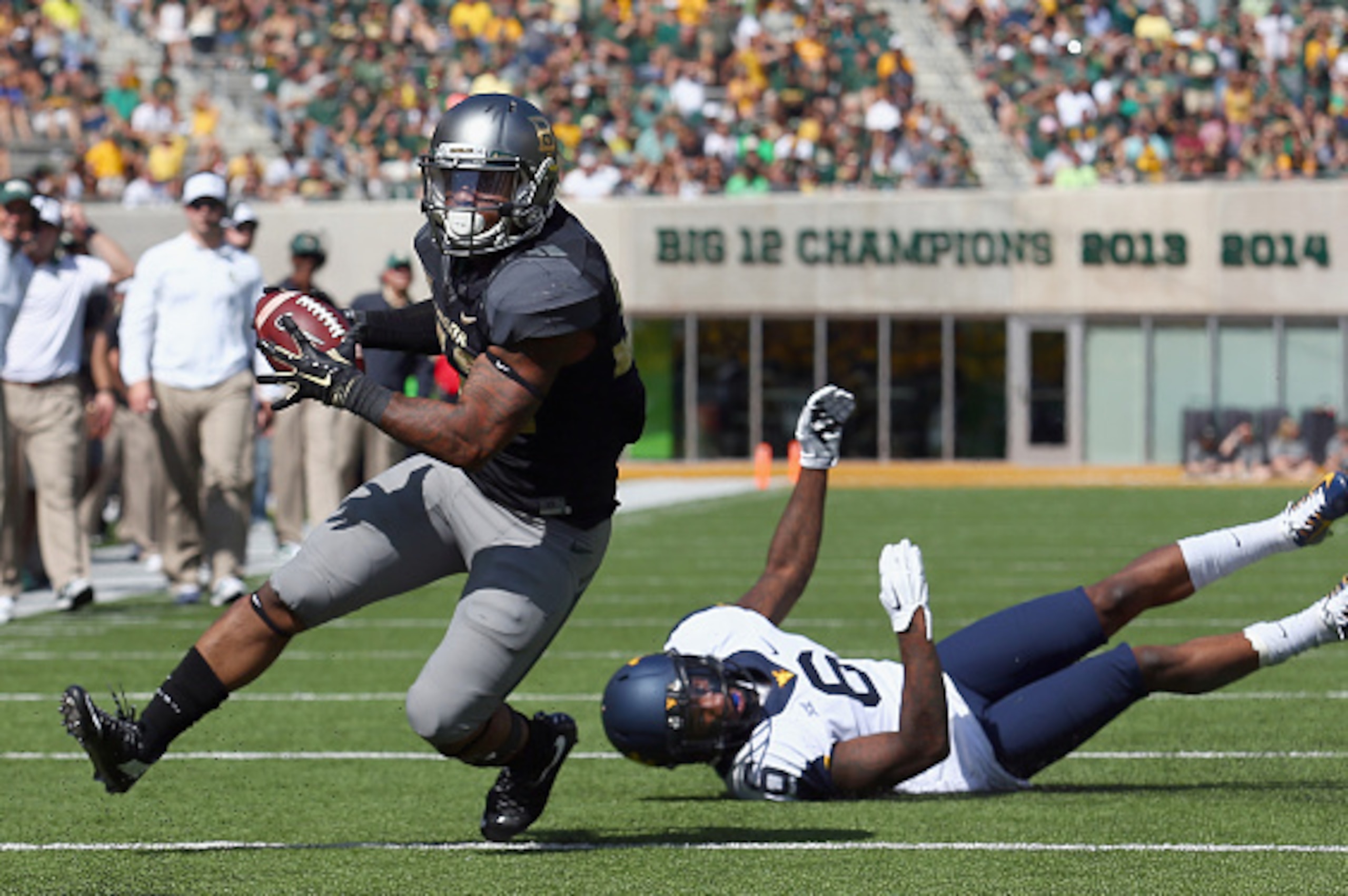 WACO, TX - OCTOBER 17:  Shock Linwood #32 of the Baylor Bears carries the ball to score a touchdown against Dravon Askew-Henry #6 of the West Virginia Mountaineers in the second half at McLane Stadium on October 17, 2015 in Waco, Texas.  (Photo by Tom Pen