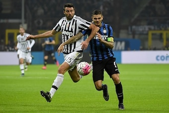 Juventus' defender from Italy Andrea Barzagli (L) fights for the ball with Inter Milan's forward from Argentina Mauro Icardi during the Italian Serie A football match Inter Milan vs Juventus on October 18, 2015 at the San Siro Stadium stadium in Milan. AF