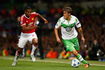 MANCHESTER, ENGLAND - SEPTEMBER 30:  Max Kruse of VfL Wolfsburg is chased by Luis Antonio Valencia of Manchester United during the UEFA Champions League Group B match between Manchester United FC and VfL Wolfsburg at Old Trafford on September 30, 2015 in 