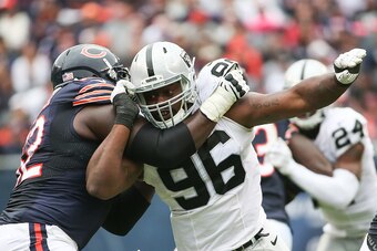 CHICAGO, IL - OCTOBER 04:   Vladimir Ducasse #62 of the Chicago Bears holds onto  Denico Autry #96 of the Oakland Raiders in the third quarter at Soldier Field on October 4, 2015 in Chicago, Illinois.  The Bears defeat the Oakland Raiders 22-20.  (Photo b