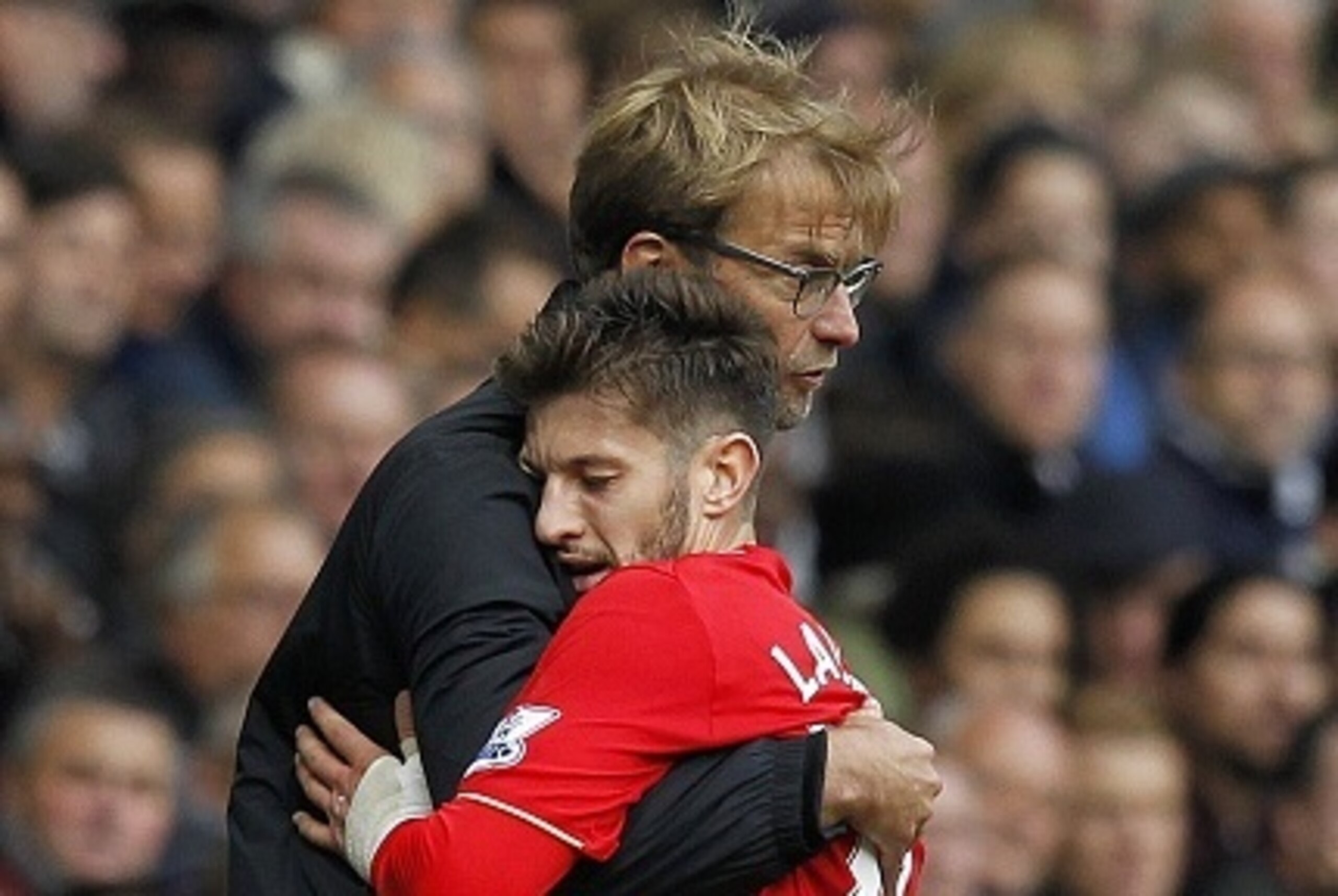 Liverpool's German manager Jurgen Klopp embraces Liverpool's English midfielder Adam Lallana (R) as he is substituted during the English Premier League football match between Tottenham Hotspur and Liverpool at White Hart Lane in north London on October 17