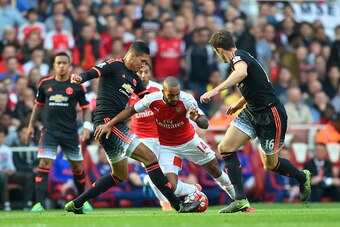 LONDON, ENGLAND - OCTOBER 04:  Theo Walcott of Arsenal is tackled by Chris Smalling of Manchester United during the Barclays Premier League match between Arsenal and Manchester United at Emirates Stadium on October 4, 2015 in London, England.  (Photo by M
