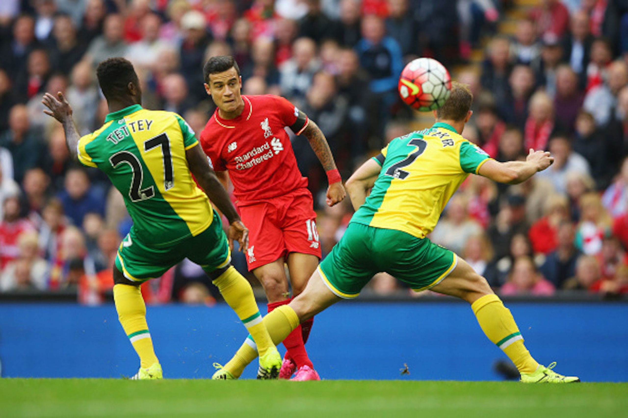 LIVERPOOL, ENGLAND - SEPTEMBER 20:  Philippe Coutinho of Liverpool shoots past Alexander Tettey (27) and Steven Whittaker of Norwich City (2) during the Barclays Premier League match between Liverpool and Norwich City at Anfield on September 20, 2015 in L