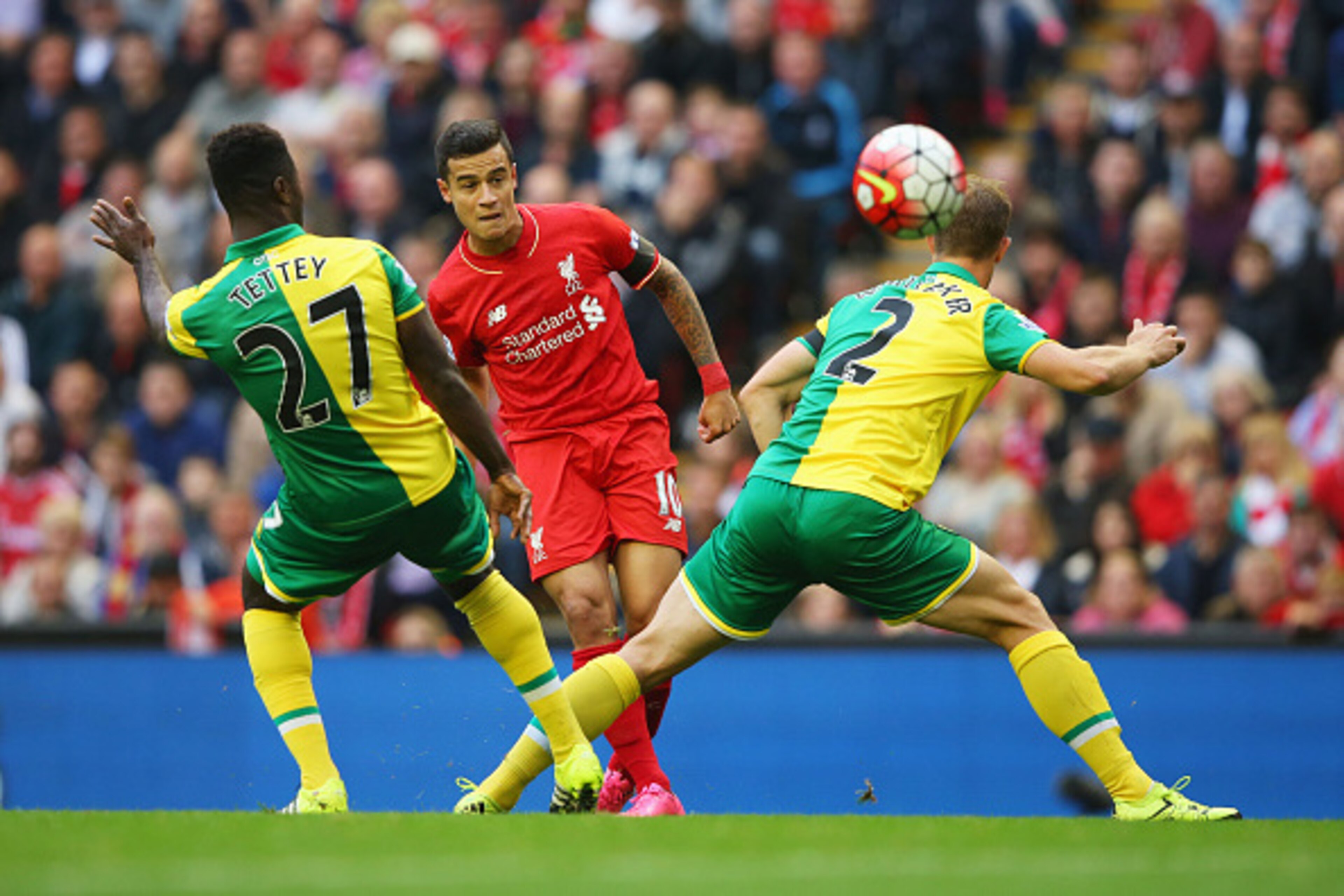 LIVERPOOL, ENGLAND - SEPTEMBER 20:  Philippe Coutinho of Liverpool shoots past Alexander Tettey (27) and Steven Whittaker of Norwich City (2) during the Barclays Premier League match between Liverpool and Norwich City at Anfield on September 20, 2015 in L