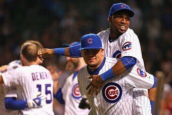 CHICAGO, IL - JULY 27:  Jonathan Herrera #19 of the Chicago Cubs jumps on the back of teammate Kyle Schwarber #12 after a win over the Colorado Rockies at Wrigley Field on July 27, 2015 in Chicago, Illinois. The Cubs defeated the Rockies 9-8.  (Photo by J