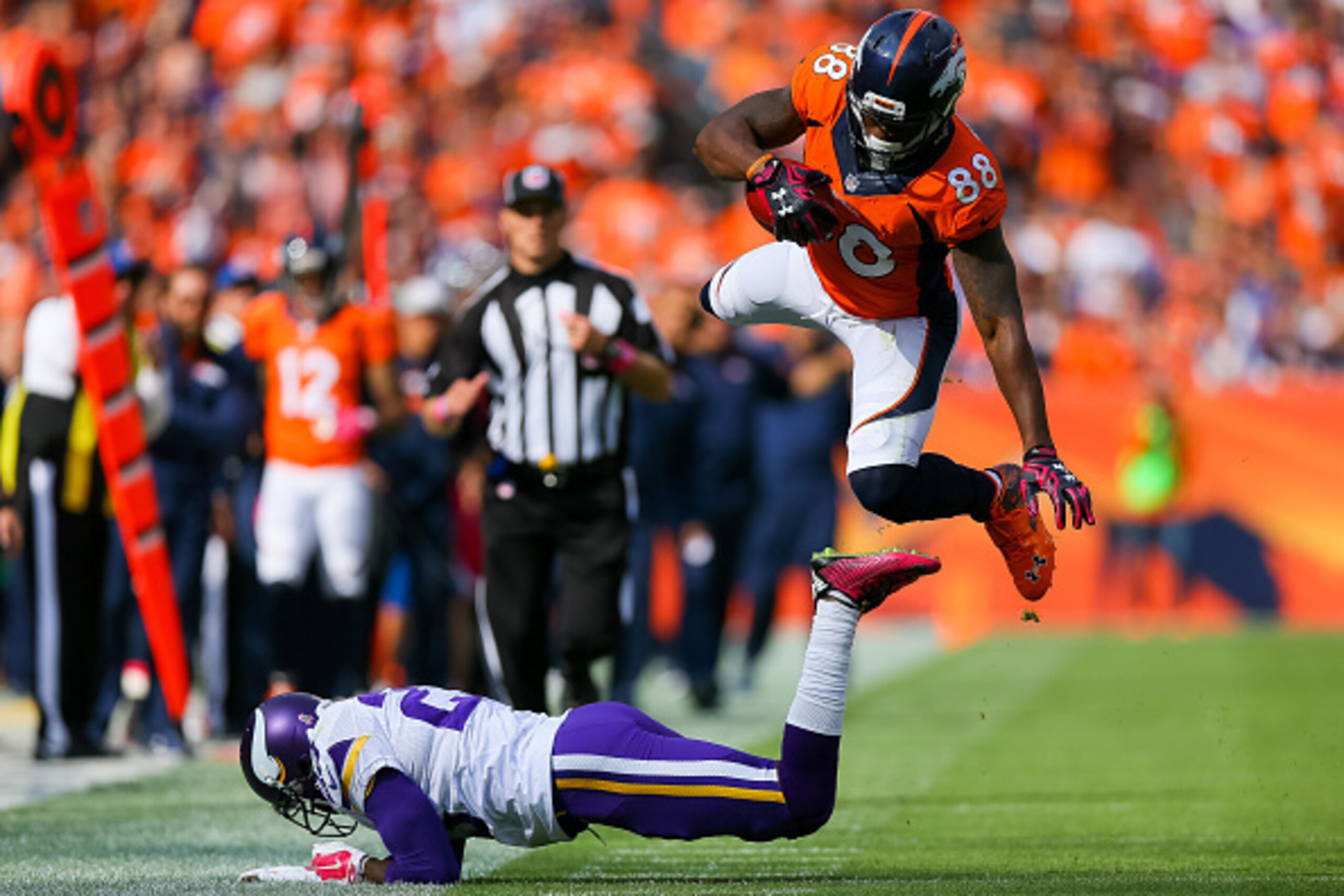 DENVER, CO - OCTOBER 4:  Wide receiver Demaryius Thomas #88 of the Denver Broncos flies through the air after being hit by cornerback Terence Newman #23 of the Minnesota Vikings on a 30 yard completion in the second quarter of a game at Sports Authority F