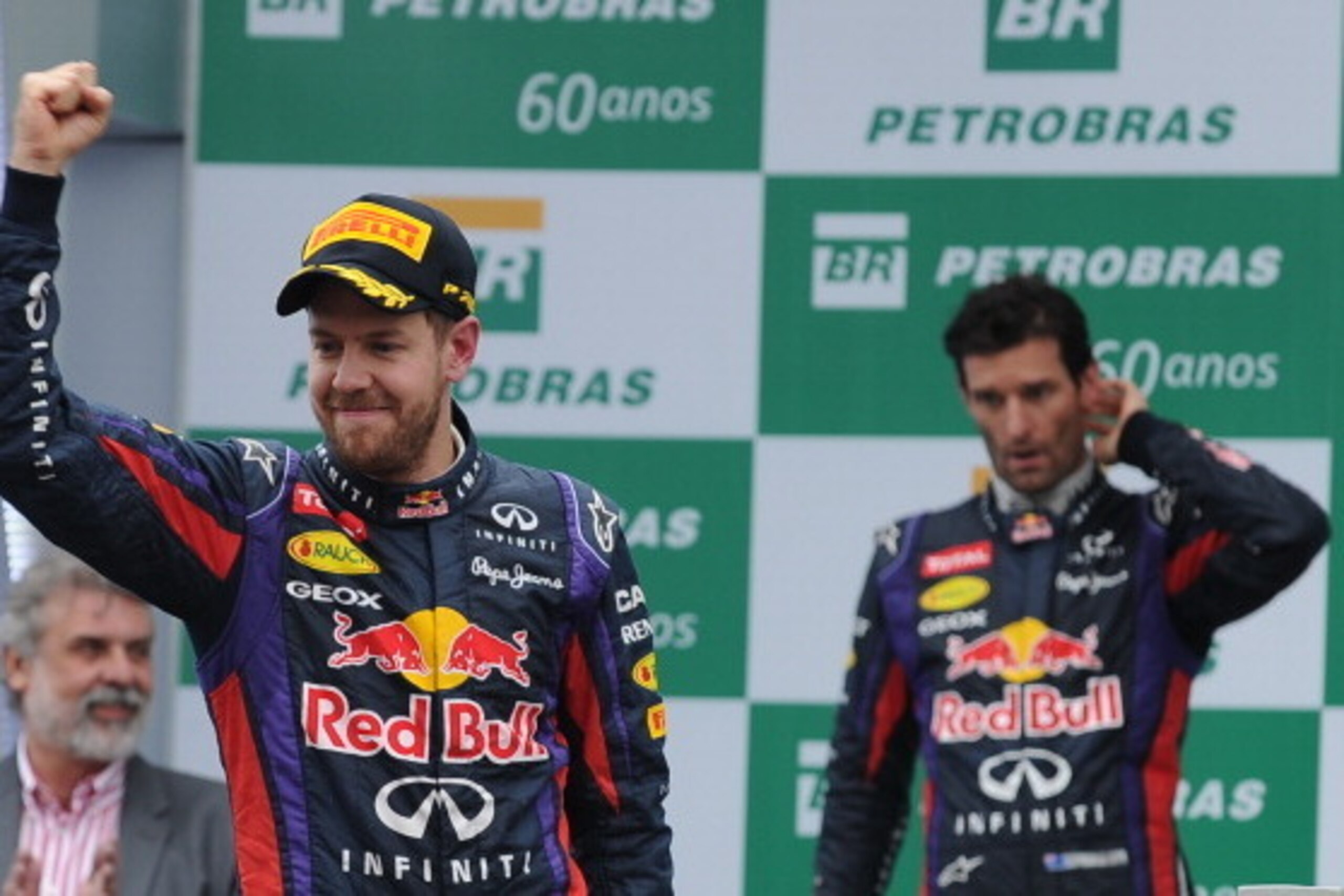 German driver Sebastian Vettel of Red Bull (L) celebrates his victory in the podium beside his fellow driver Australian Mark Webber in the Brazilian Formula one Grand Prix at the Interlagos racetrack in Sao Paulo, Brazil, on November 24, 2013.Vettel is fo