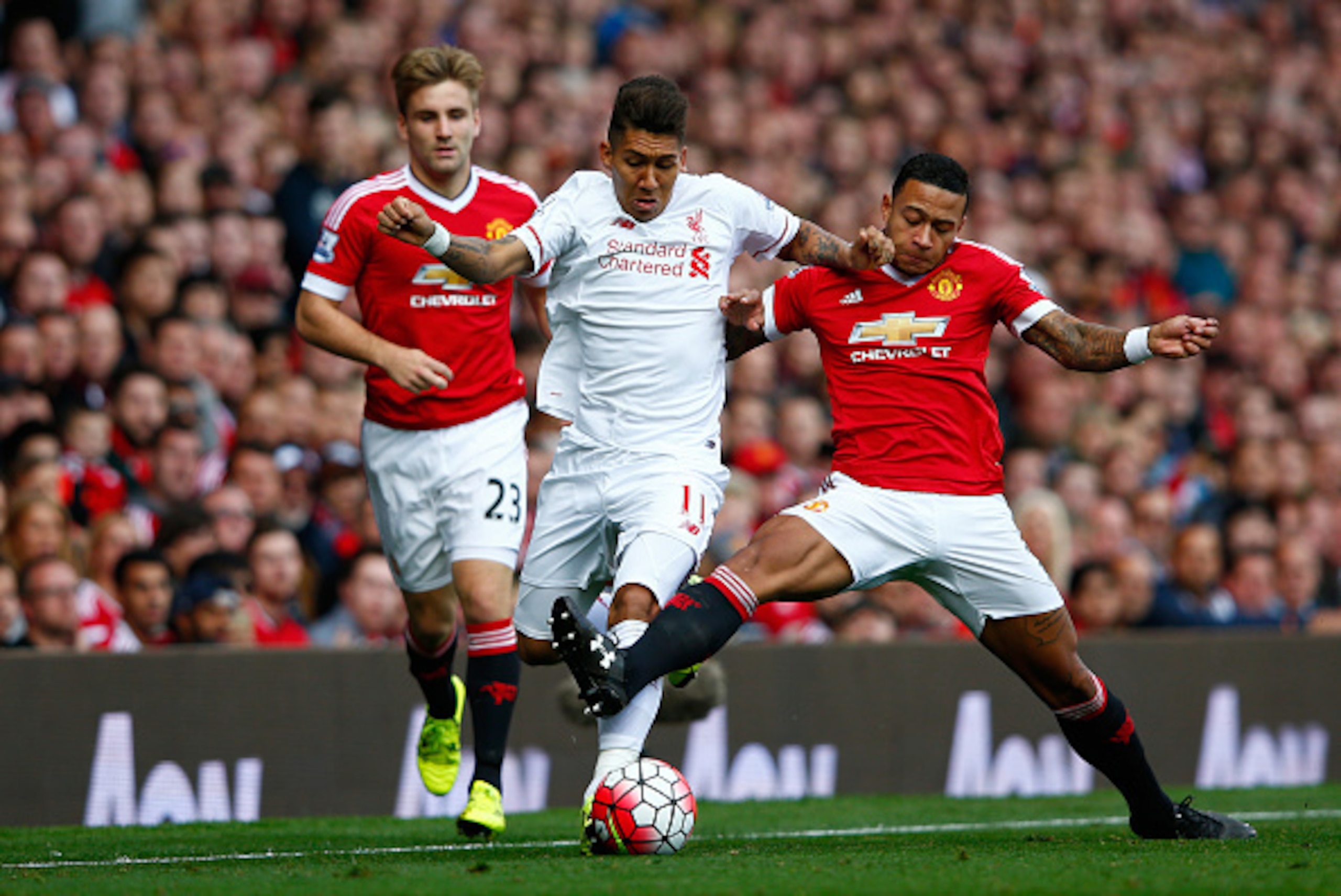 MANCHESTER, ENGLAND - SEPTEMBER 12:  Roberto Firmino of Liverpool is challenged by Memphis Depay of Manchester United during the Barclays Premier League match between Manchester United and Liverpool at Old Trafford on September 12, 2015 in Manchester, Uni