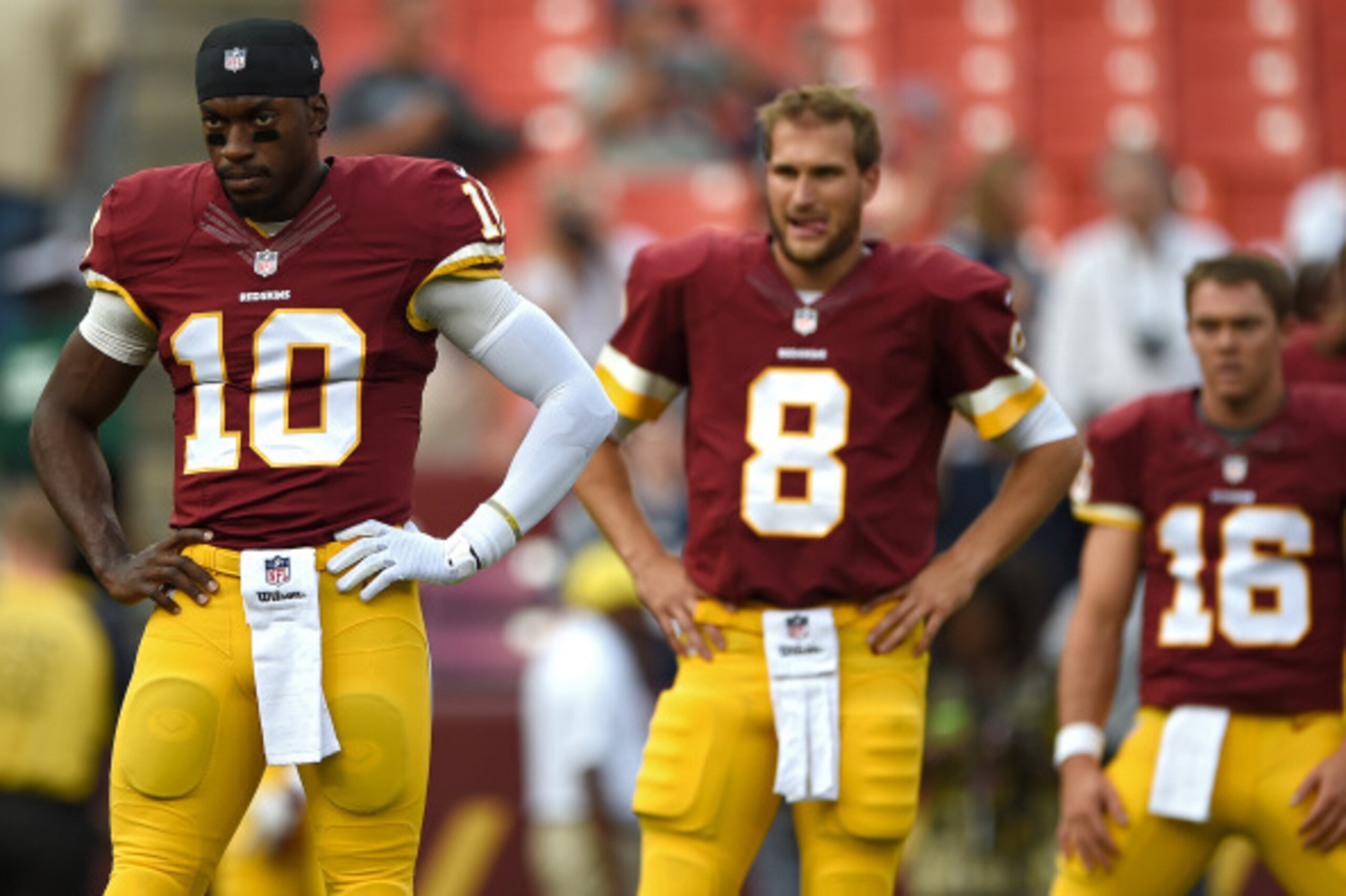 LANDOVER, MD - AUGUST 07: Quarterback Robert Griffin III #10, quarterback Kirk Cousins #8, and quarterback Colt McCoy #16 of the Washington Redskins look on before playing the New England Patriots during their preseason NFL game at FedExField on August 7,