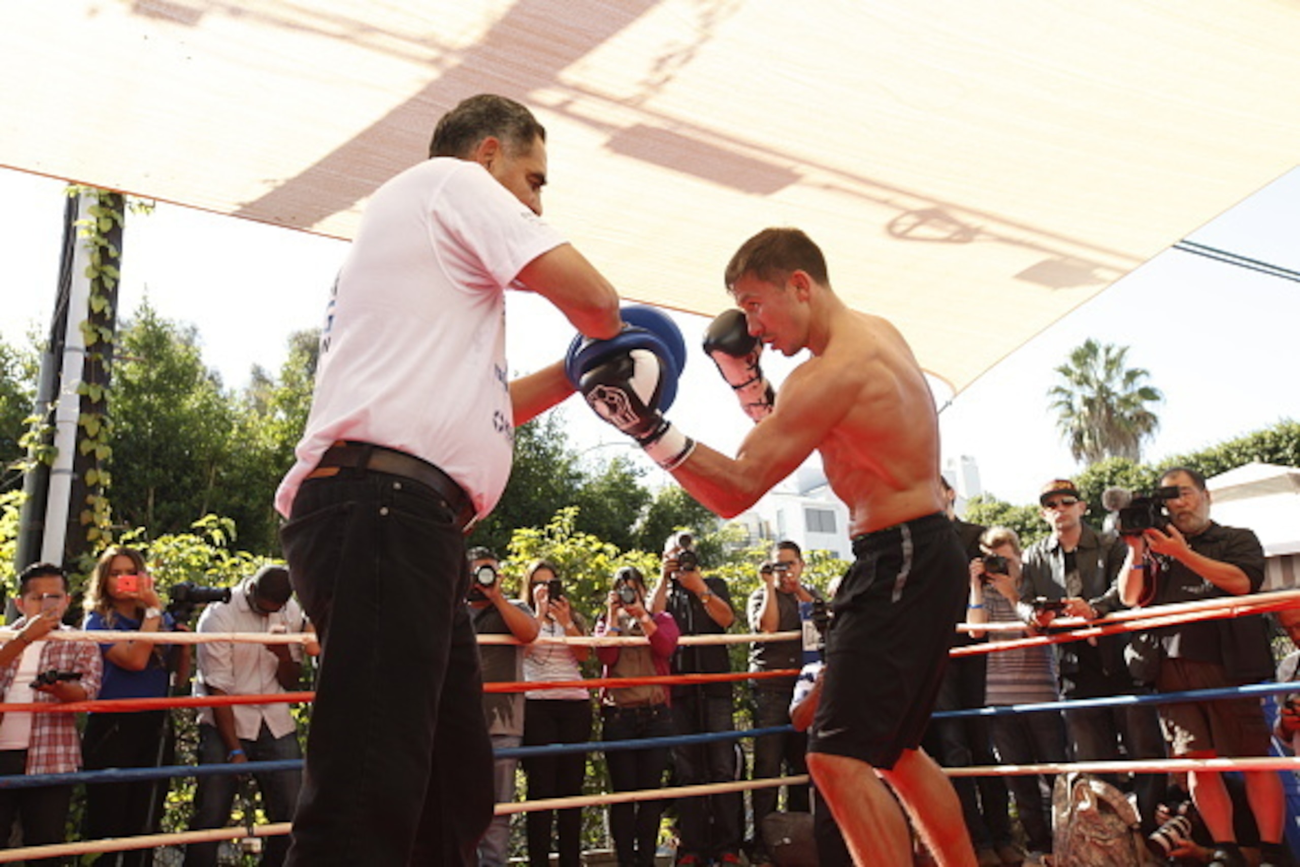 SANTA MONICA, CA - OCTOBER 15: Gennady Golovkin (R) hits the mitts with his trainer Abel Sanchez during an open media workout on October 15, 2014 in Santa Monica, California.  (Photo by Alexis Cuarezma/Getty Images)